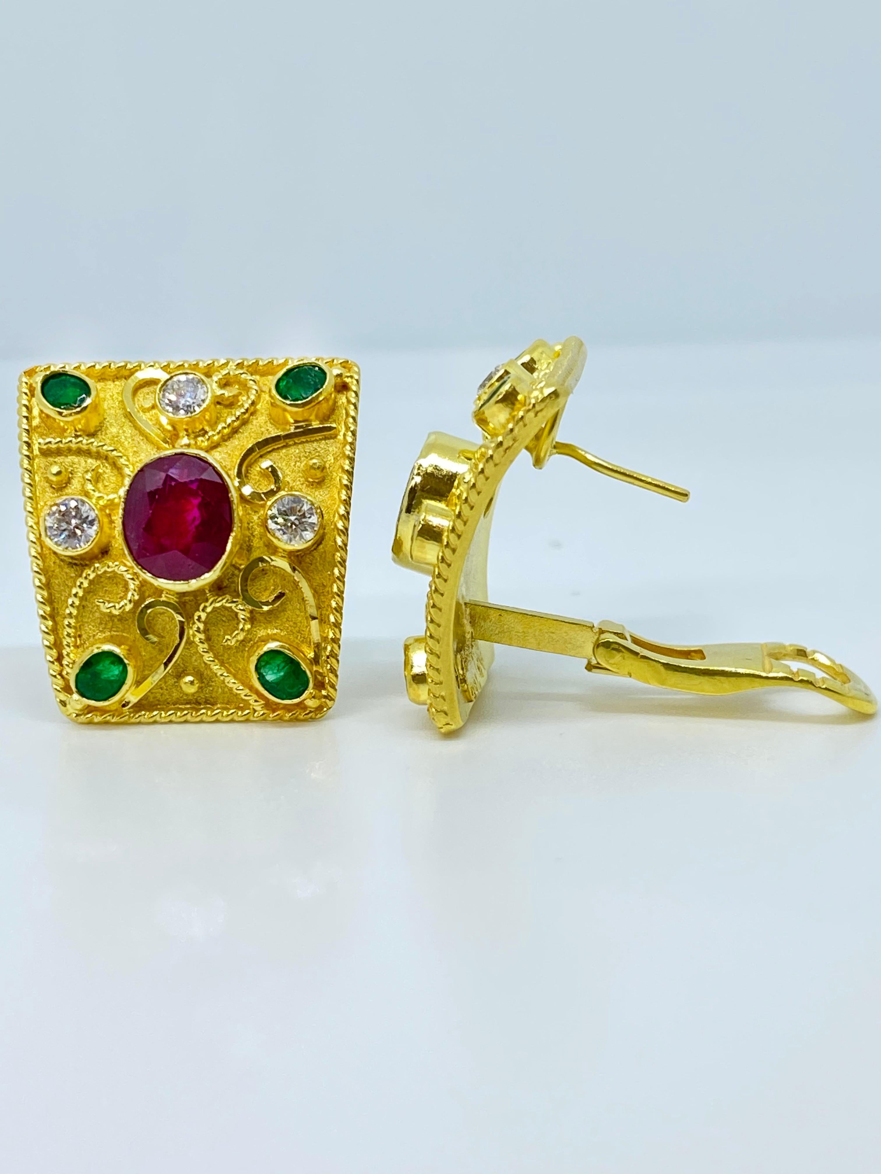 These S.Georgios designer earrings are hand made from 18 Karat Yellow Gold and decorated with Byzantine-era style granulation workmanship done piece by piece microscopically. . These beautiful curved earrings feature 2 Oval cut Rubies surrounded by