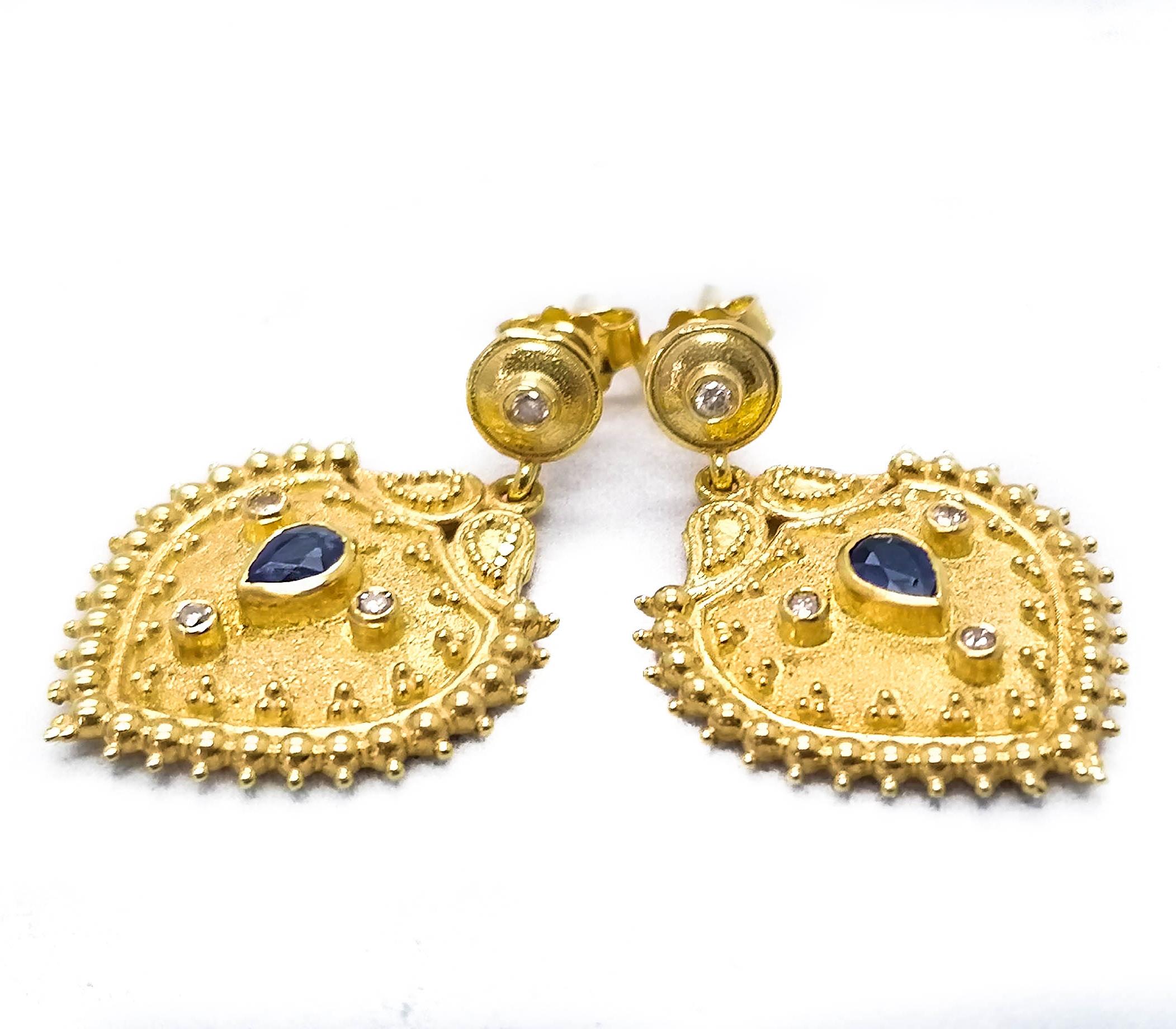 These S.Georgios 18 Karat Yellow Gold designer earrings are decorated with hand made Byzantine-era style bead granulation workmanship, and finished with a unique velvet background. These beautiful earrings feature 2 pear shape natural Blue Sapphires