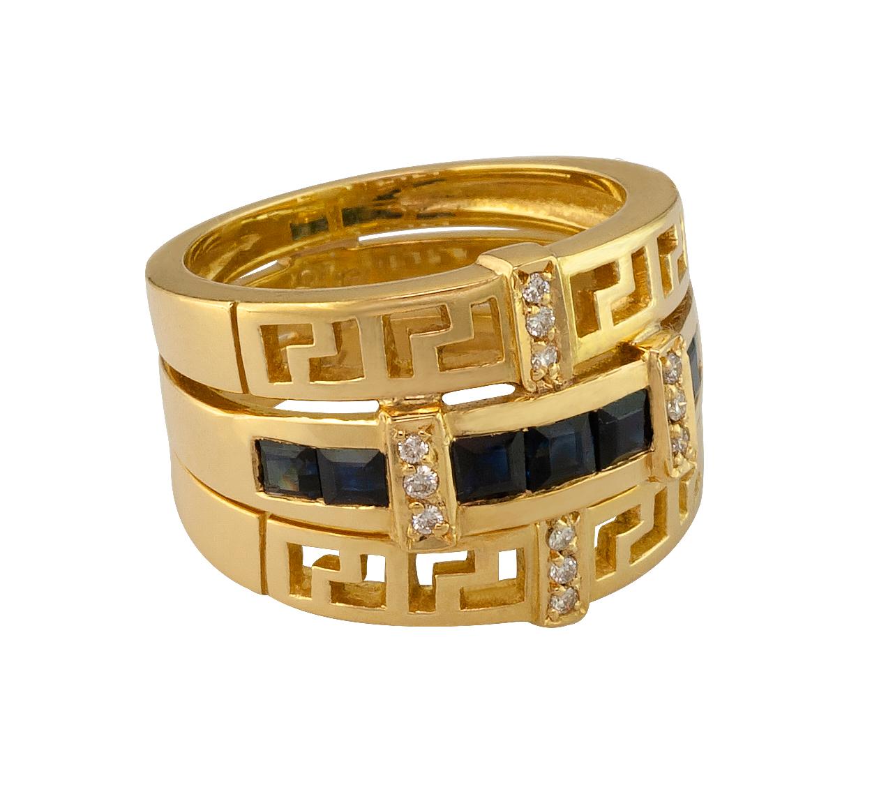 S.Georgios designer 18 Karat Yellow Gold Ring features the Greek Key design which symbolizes eternity. The gorgeous band has 12 Brilliant Cut White Diamonds total weight of 0.11 Carat and 7 Princess cut  Sapphires total weight of 1.45 Carat. 
The