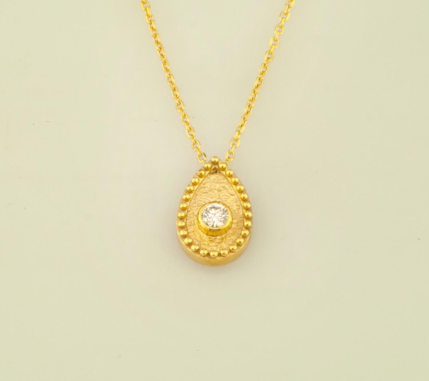 This S.Georgios designer pendant necklace is 18 Karat yellow gold and microscopically decorated with hand-made bead granulation workmanship, and finished with a unique velvet background look. This beautiful teardrop necklace features a brilliant-cut