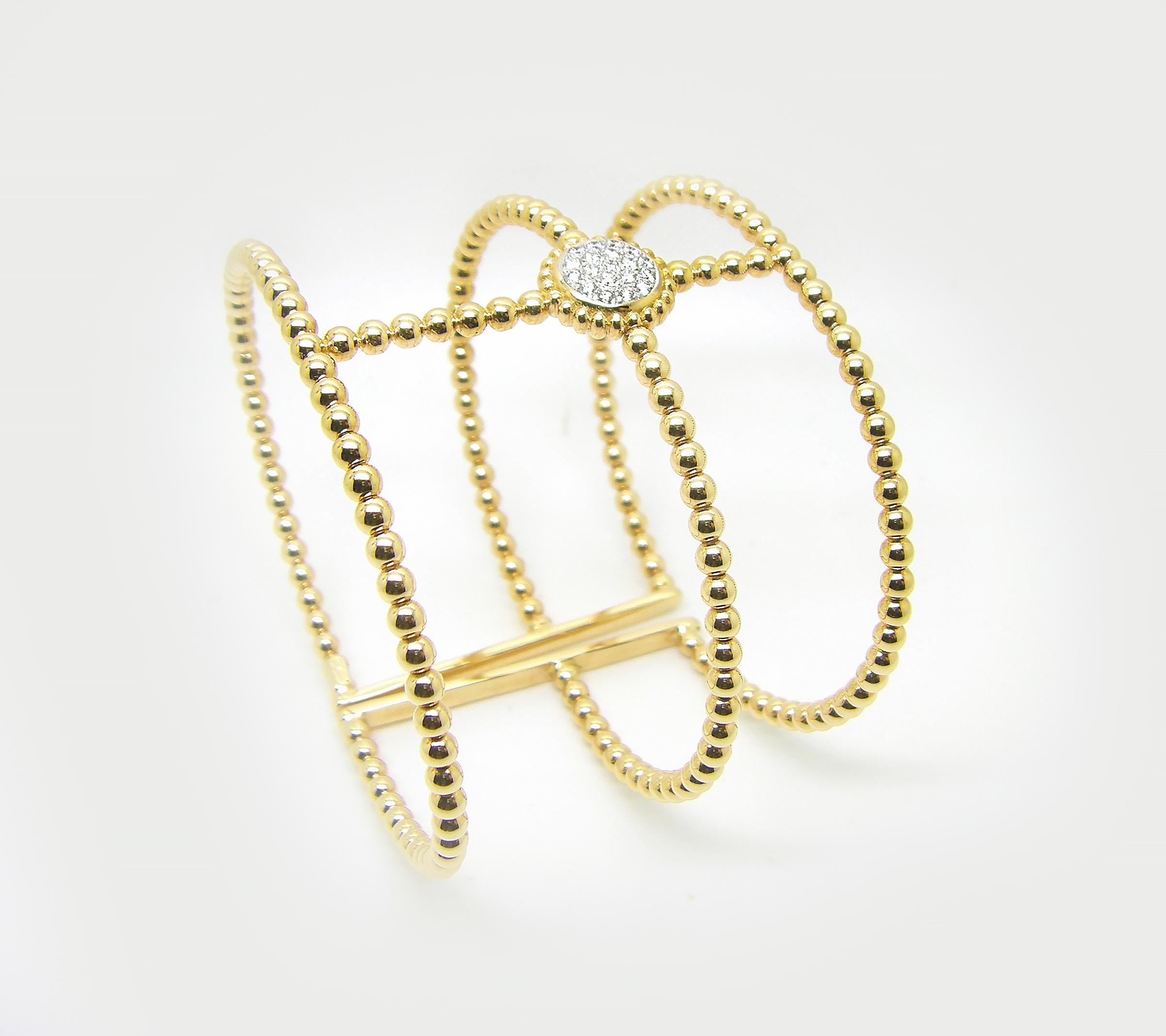 This S.Georgios designer cuff bracelet in solid yellow gold 18 karats all custom made. The gorgeous wide cuff is made of three bangles connected together in a unique way and all have the flexibility to open and close. In the center, we have set in a