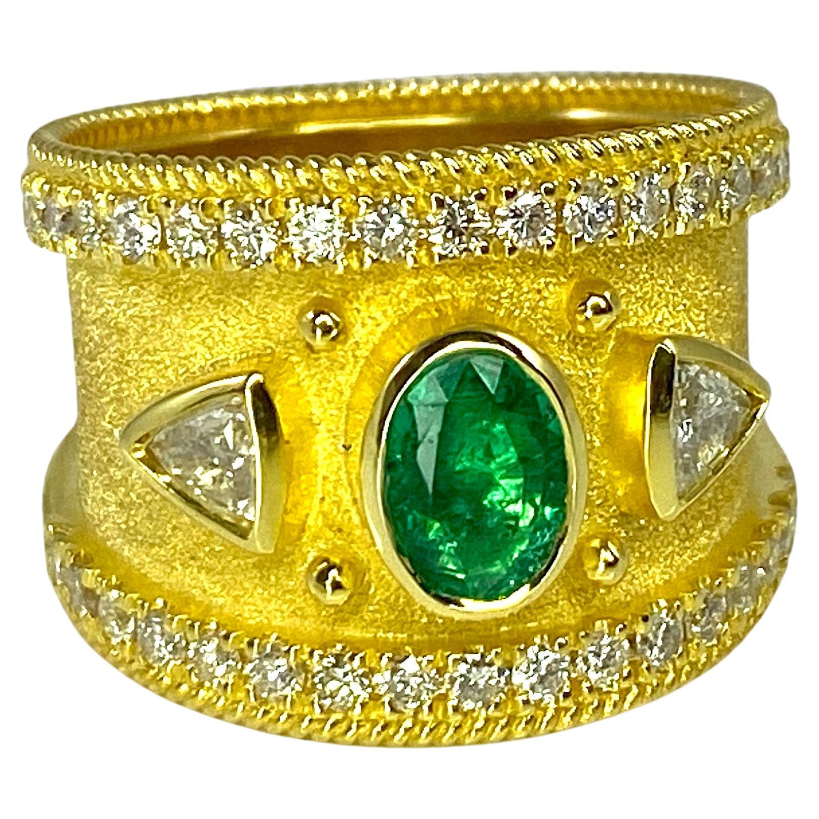 This is a stunning S.Georgios designer Ring in Yellow Gold 18 Karat all decorated with a Byzantine velvet background and granulation details - twisted wires and beads. The center of the ring features a beautiful 0.68 Carat oval cut Emerald