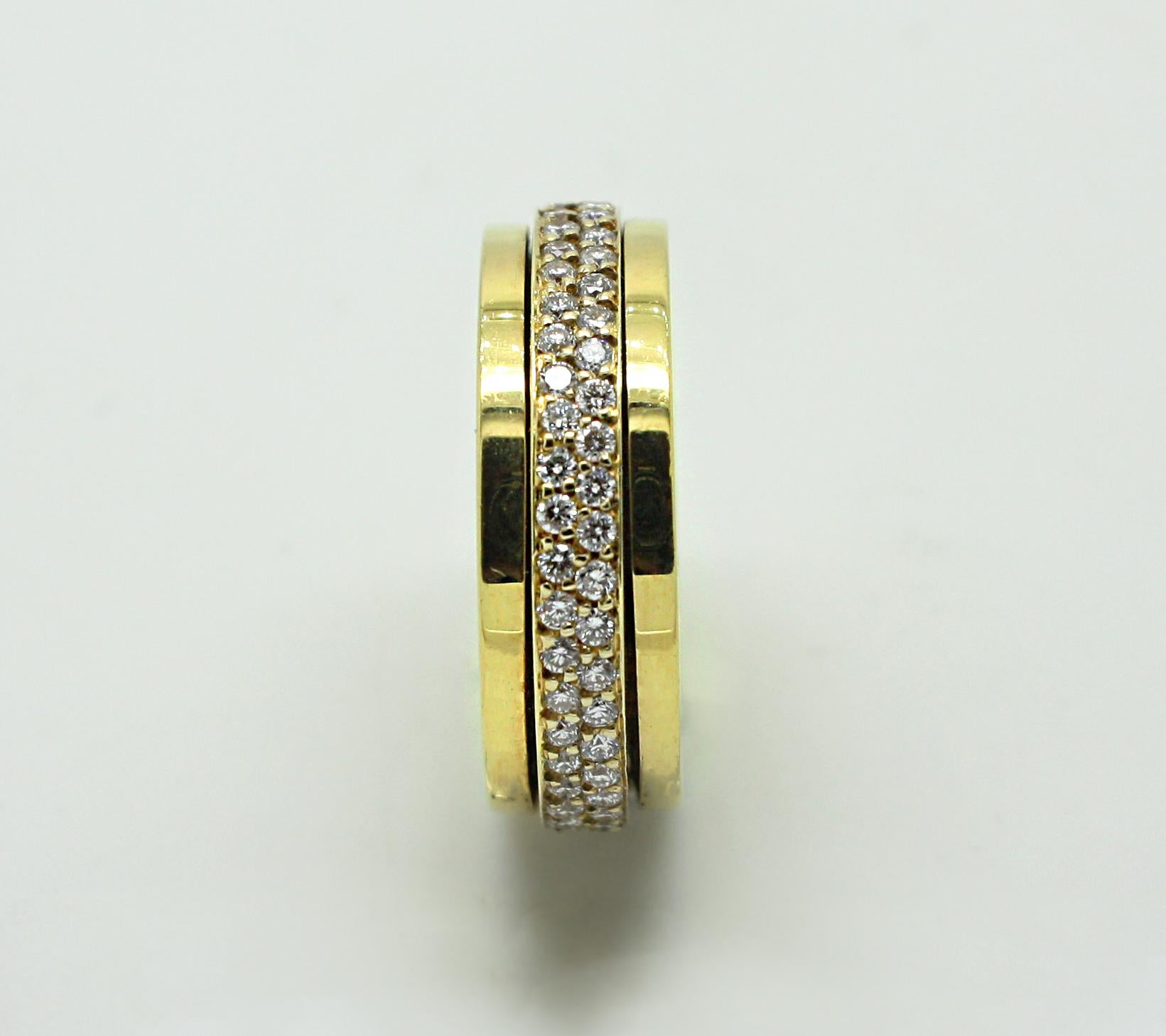 S.Georgios designer 18 Karat Yellow Gold Eternity Diamond Band Ring is all handmade and has a diamond bezel that spins freely in the middle. The gorgeous band features brilliant cut white diamonds total weight of 0.95 Carat in a microscopic