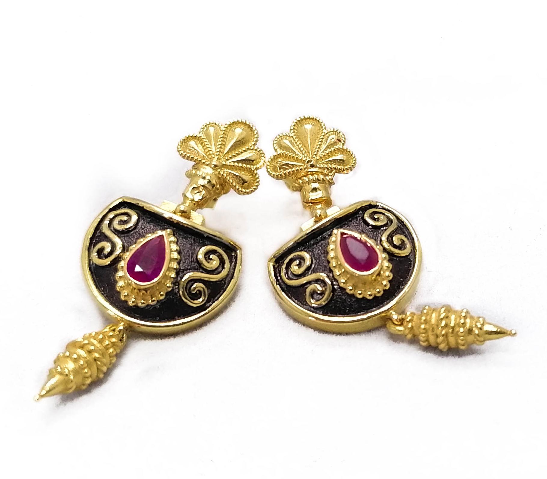 Diese S.Georgios Designer-Ohrringe sind aus 18 Karat Gelbgold handgefertigt und mit mikroskopischer Granulation im Stil der byzantinischen Ära verziert. Diese wunderschönen Tropfenohrringe sind mit 2 tropfenförmigen natürlichen Rubinen mit einem