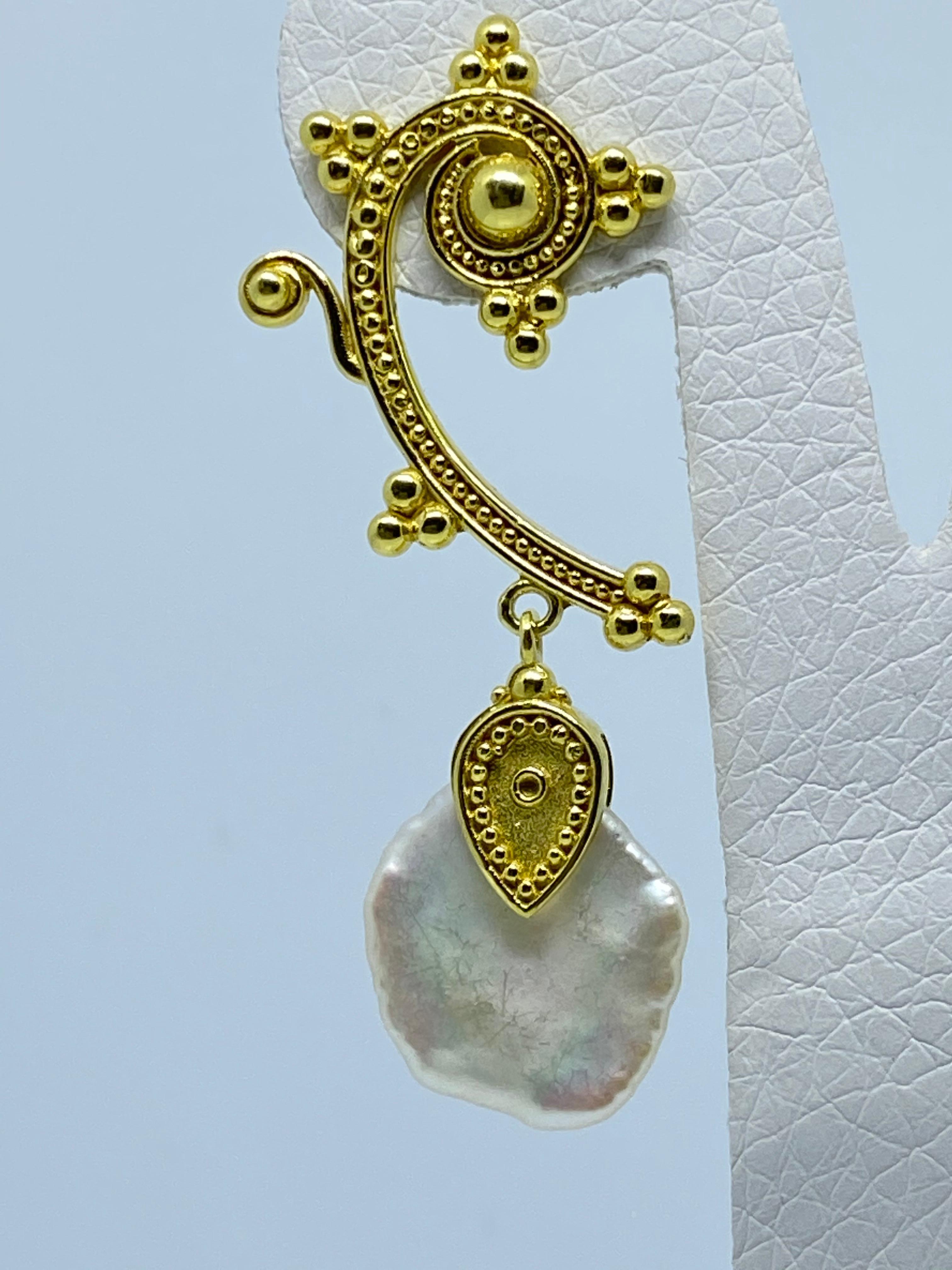 Diese S.Georgios Designer-Ohrringe sind aus 18 Karat Gelbgold handgefertigt und mit einzigartiger Granulierung im byzantinischen Stil in einer eleganten Spirale verziert, die mit 2 wunderschönen Perlmuttperlen abgeschlossen wird. Wir fertigen dieses