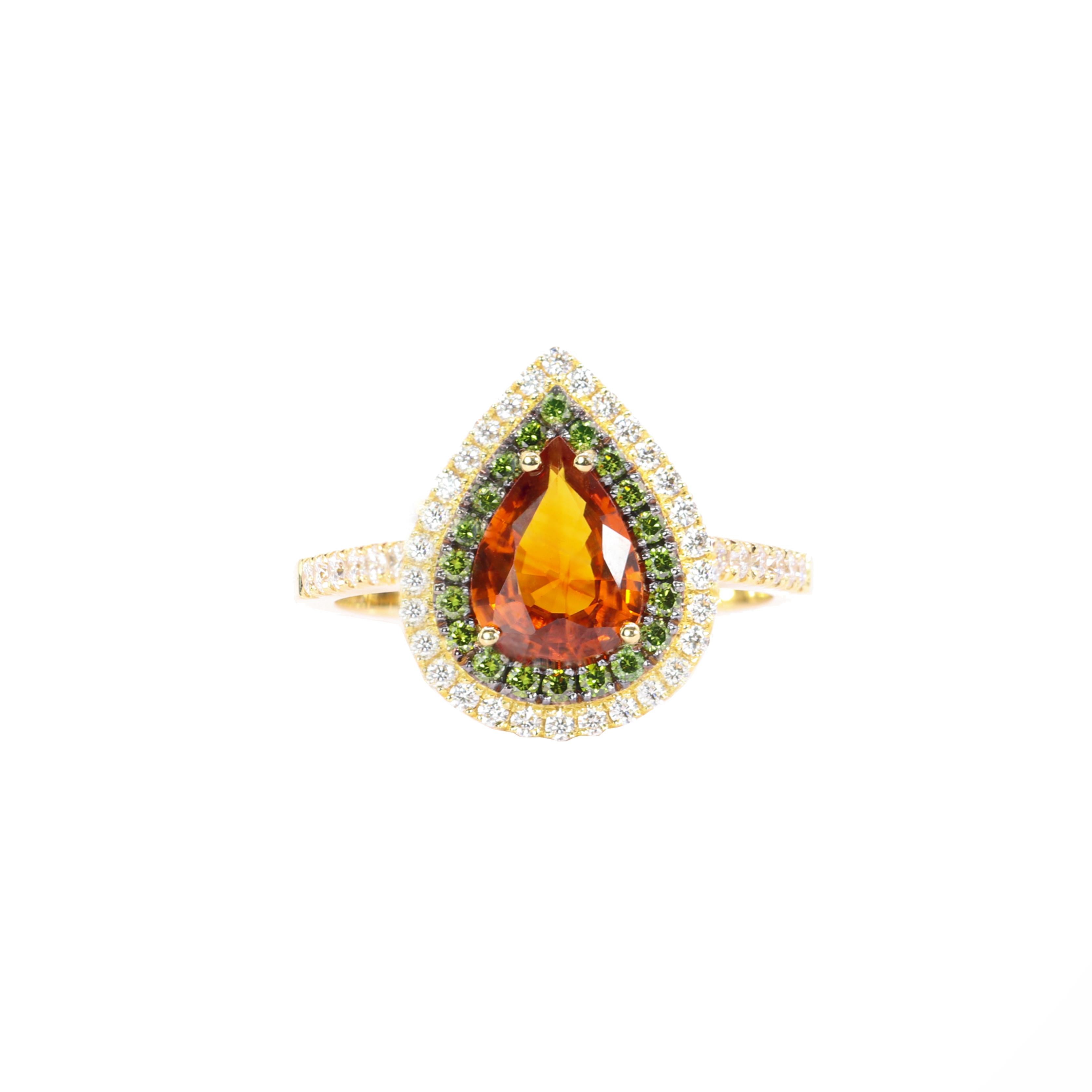 S.Georgios designer presents an exquisite 18K Yellow Gold Ring featuring a pear-cut 1,60 Carats Orange Sapphire at its center. This vibrant gemstone is elegantly surrounded by green brilliant cut diamonds, total weight of 0,20 carats and white