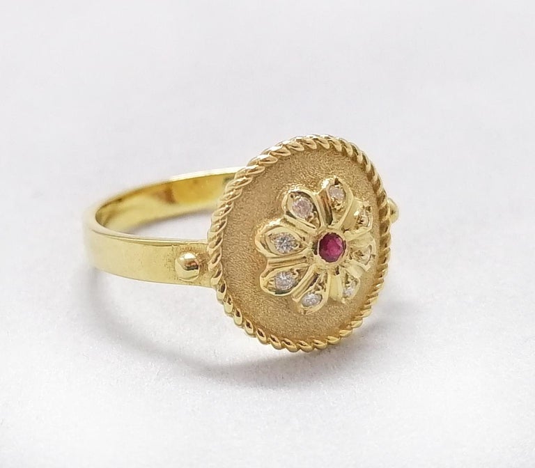 This S.Georgios designer ring is handmade from solid 18 Karat Yellow Gold and is microscopically decorated with Byzantine-style granulation work. This beautiful Floral design features an elegant center brilliant-cut Ruby total weight of 0.16 Carat,