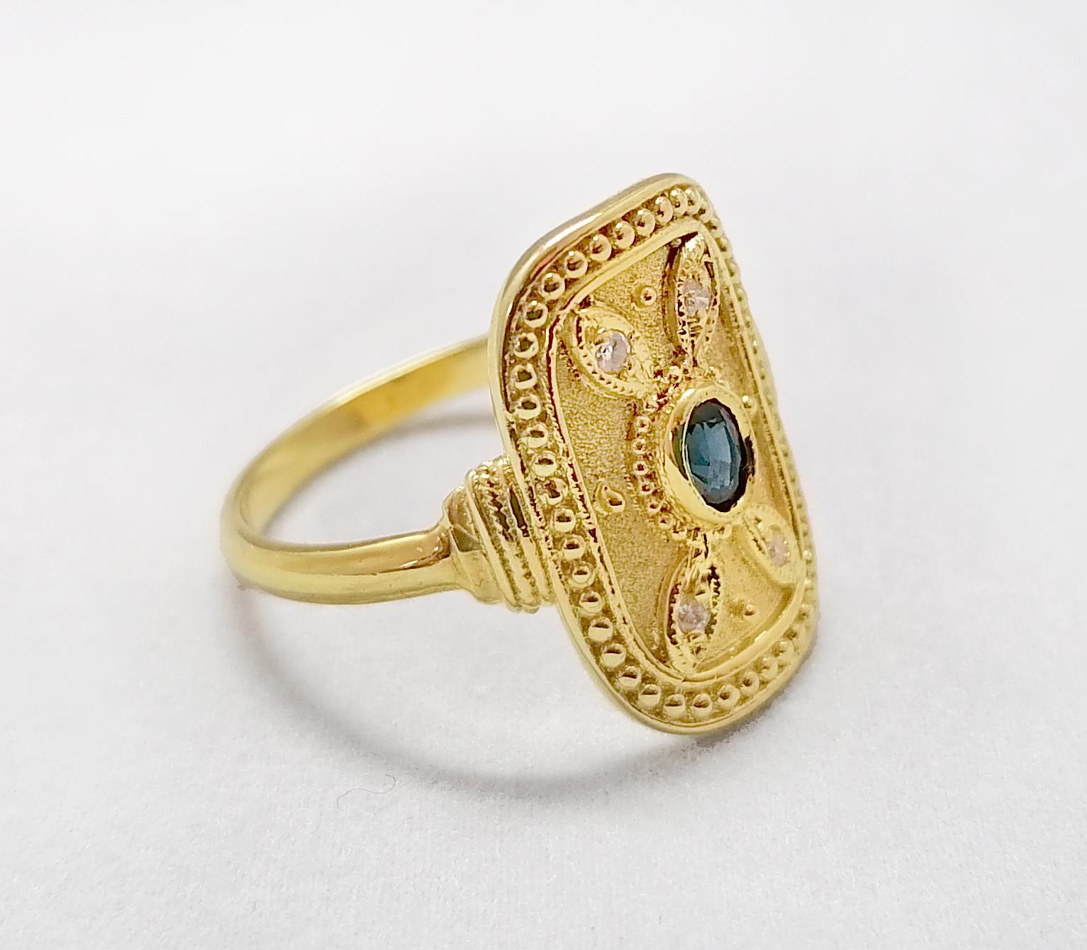 This S.Georgios designer ring is handmade from solid 18 Karat Yellow Gold and is microscopically decorated with Byzantine-style granulation work creating a stunning art piece. This beautiful long ring features an elegant center oval-cut natural