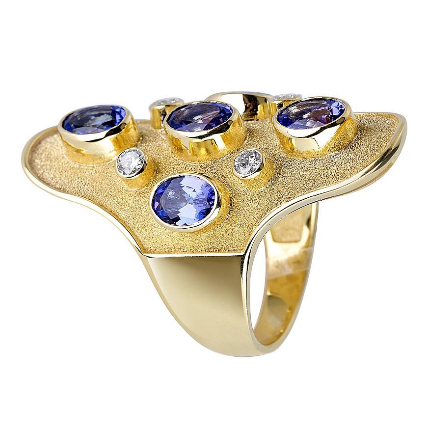 S.Georgios designer long band Ring in Solid Yellow Gold 18 Karat all handmade with Byzantine granulation workmanship and a unique microscopic velvet look on the background. This gorgeous band ring is decorated with 5 natural oval Tanzanites total