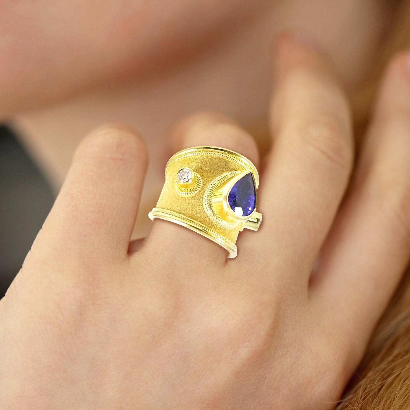 Unique S.Georgios designer 18 Karat Solid Yellow Gold Ring all handmade with the Byzantine granulation workmanship and a stunning velvet background. The Ring has 1 center Pear Shape Tanzanite total weight of 3,20 Carats and 2 Brilliant cut White