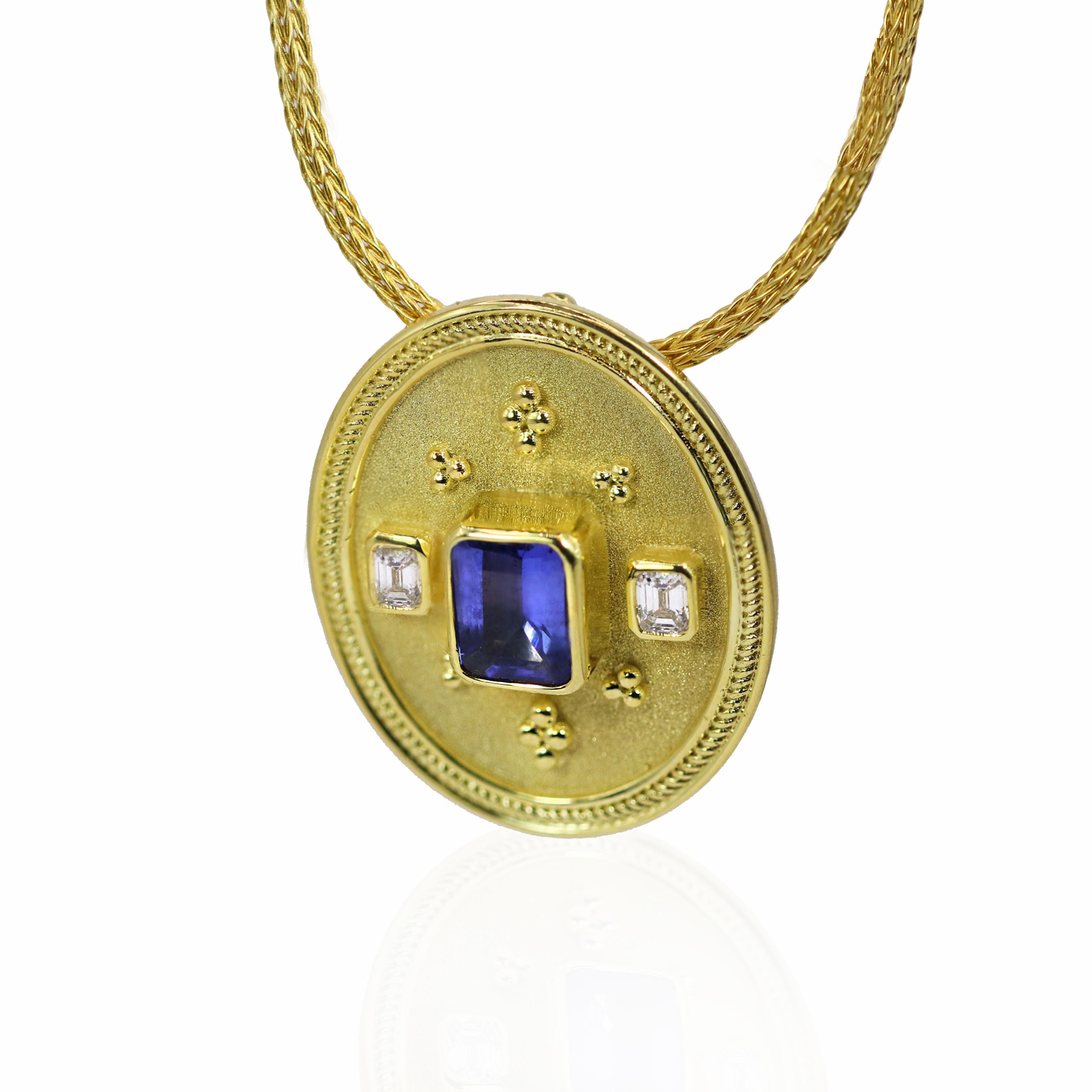 Le collier à pendentifs S.Georgios est fabriqué à la main en or jaune massif 18 carats dans un style byzantin exquis. Il est orné en son centre d'une Tanzanite de taille émeraude d'un poids de 2,36 carats. La riche teinte bleue de la tanzanite est