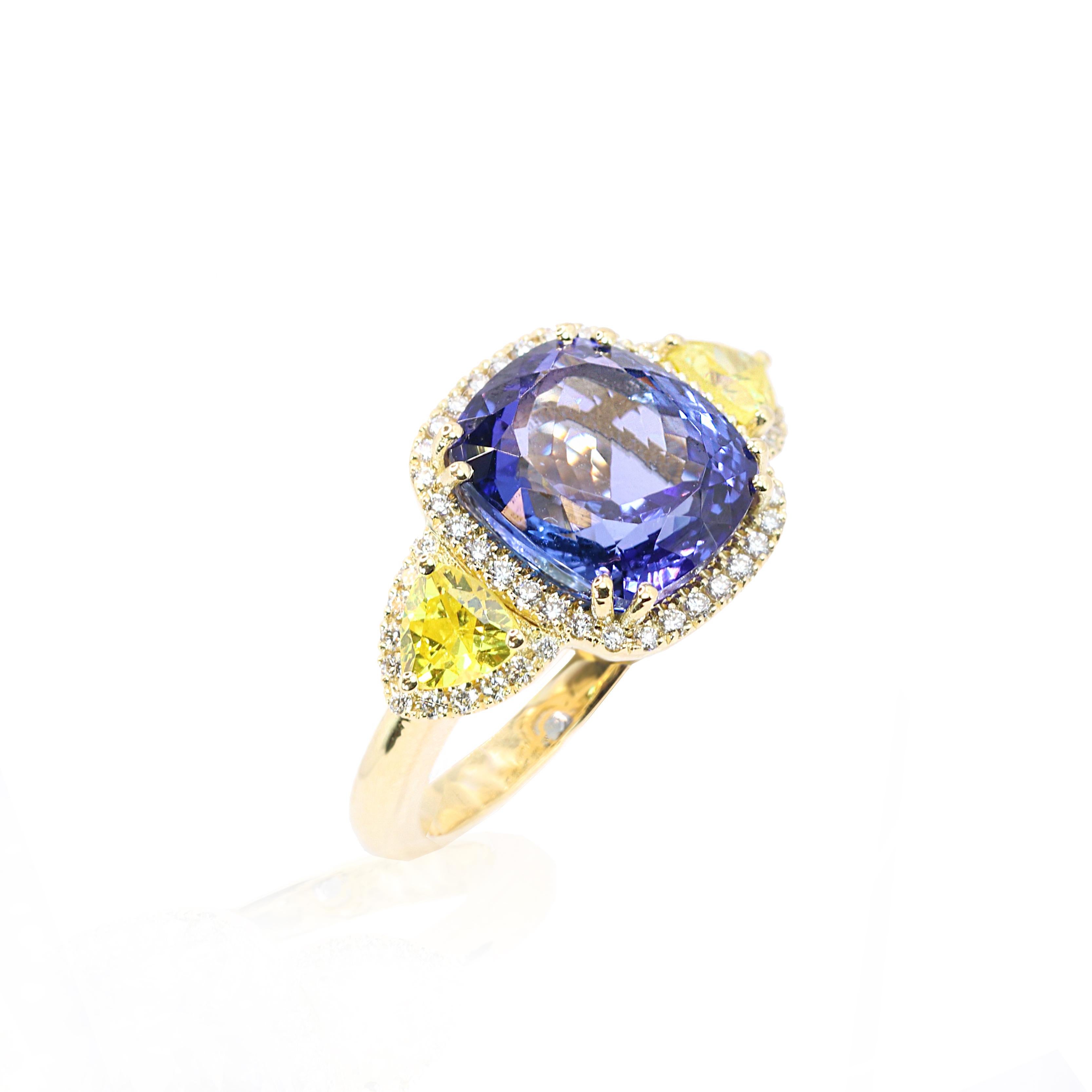 S.Georgios designer presents an exquisite 18K Yellow Gold Ring featuring an oval-cut 7.95 Carats Tanzanite at its center. This stunning gemstone is elegantly surrounded by a halo of white diamonds. Flanking the central sapphire are two trillion-cut