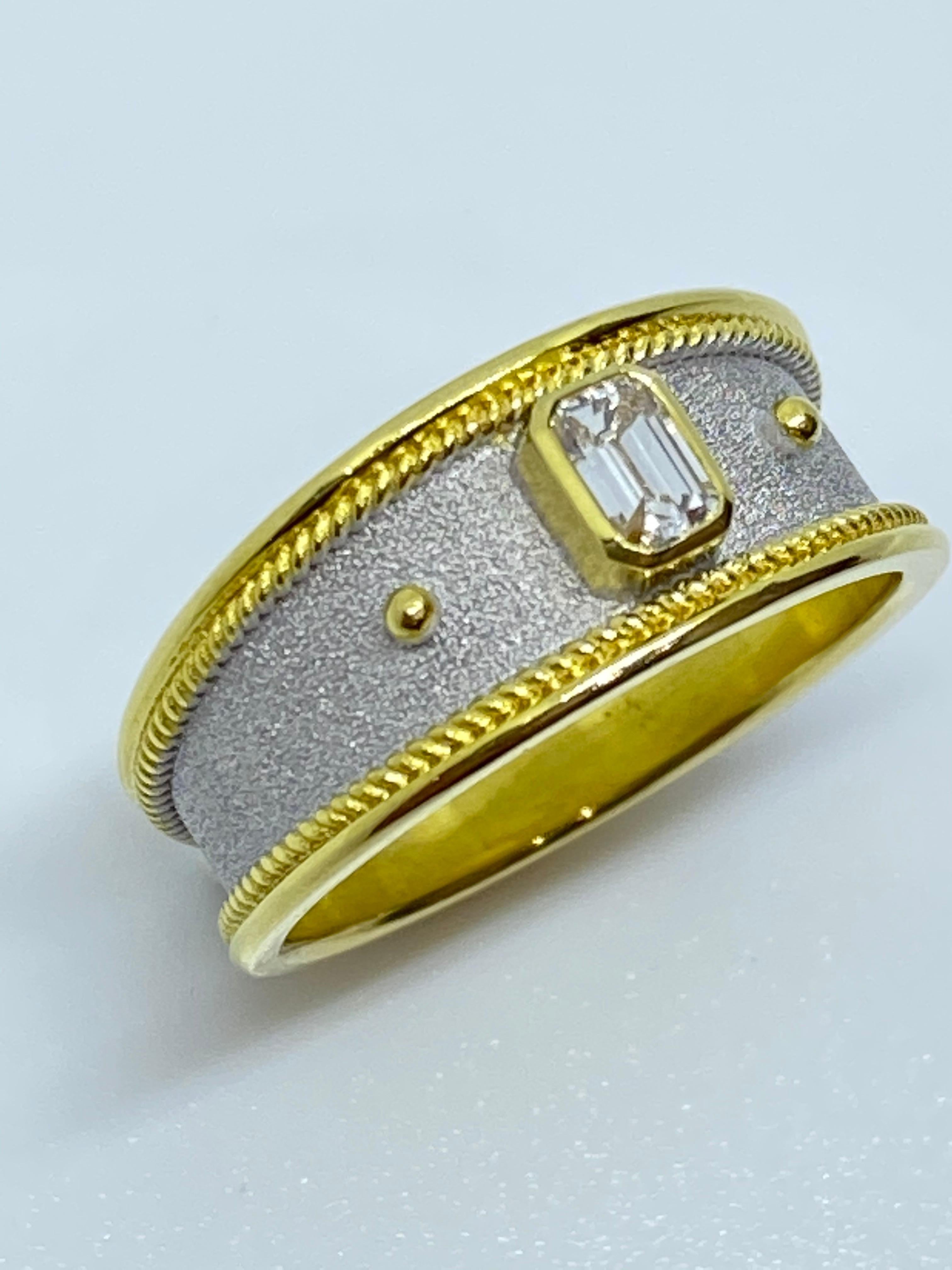 This S.Georgios designer band ring is made in 18 Karat Yellow Gold all handmade with Byzantine workmanship. This stunning piece has granulation work and a unique velvet background finished with white Rhodium. The gorgeous band ring features a VVS1