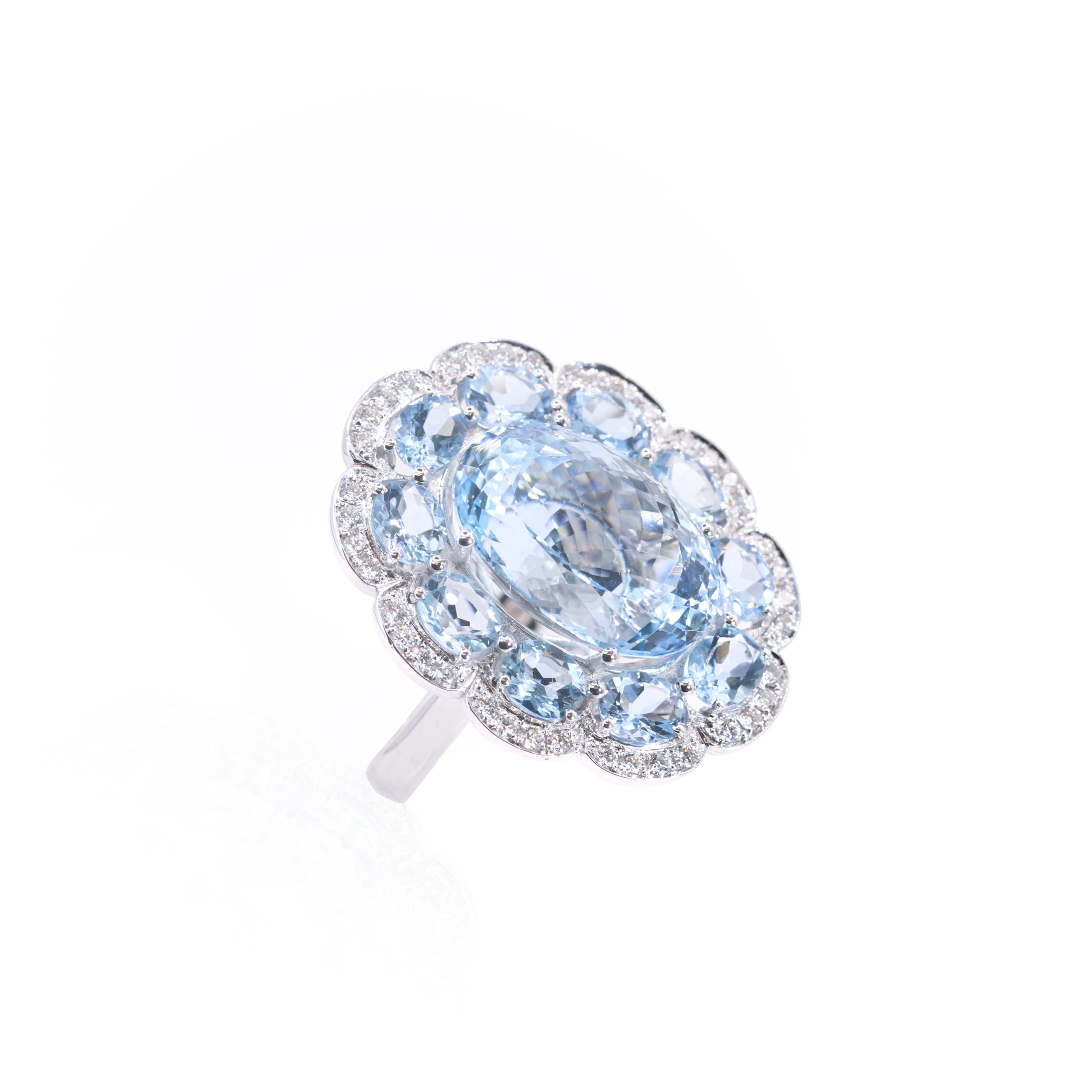 S.Georgios designer presents a magnificent 18 Karat White Gold Ring featuring a 11.10 Carats oval-cut Aquamarine at the center,  forming the heart of a beautiful flower design. The petals of this exquisite flower are smaller oval aquamarines total