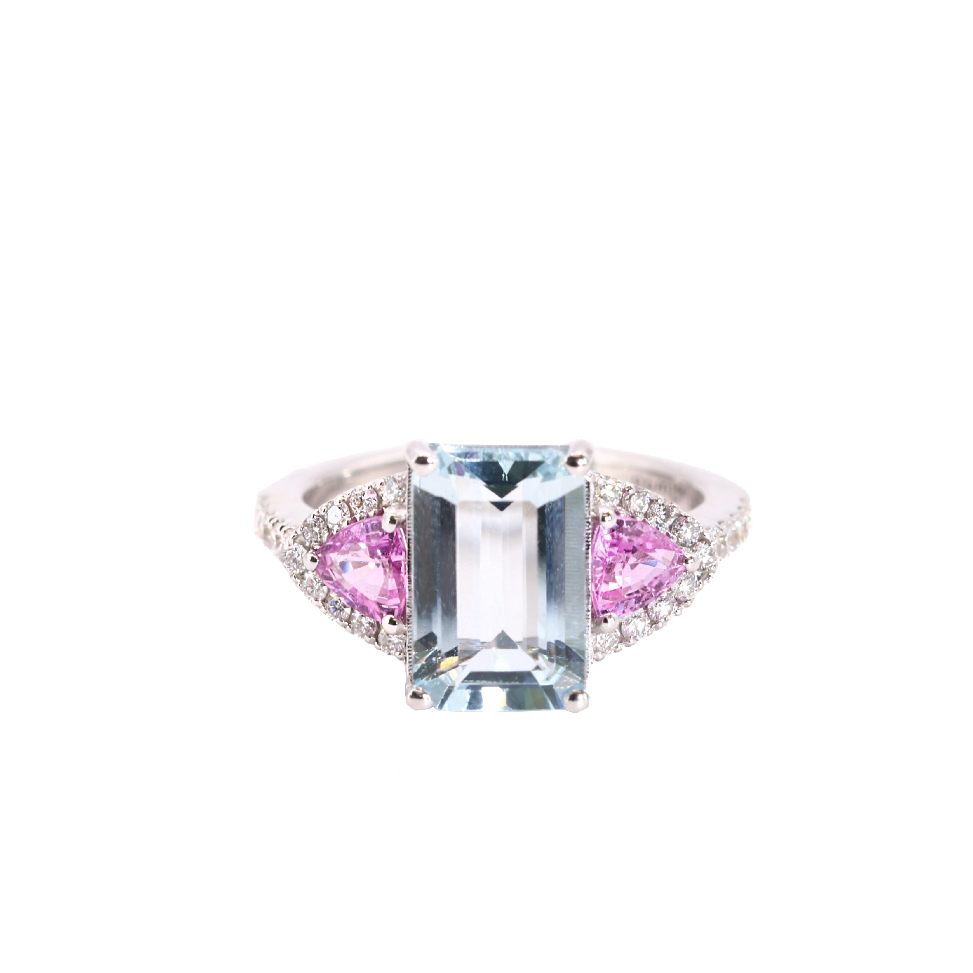 S.Georgios designer presents a captivating 18K White Gold Ring featuring a stunning emerald-cut Aquamarine total weight of 2.66 Carats, at the center. Flanked by two trillion-cut Pink Sapphires, total weight of 0.87 Carats on each side , the