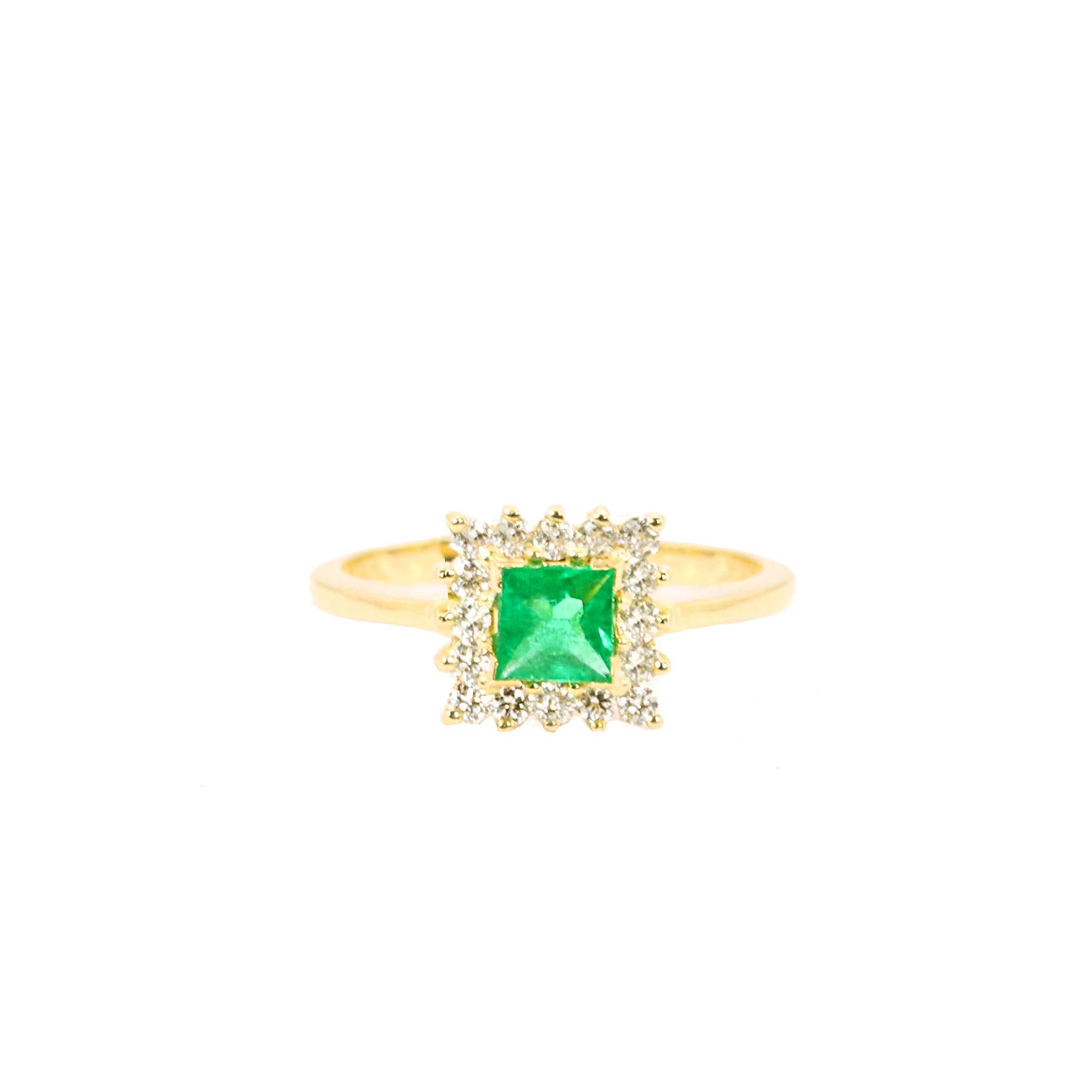 S.Georgios designer presents an exquisite 18 Karat Yellow Gold Ring featuring a stunning princess-cut Emerald stone at the center, weighing 0.37 carats. This vibrant emerald is elegantly surrounded by brilliant-cut diamonds with a total weight of