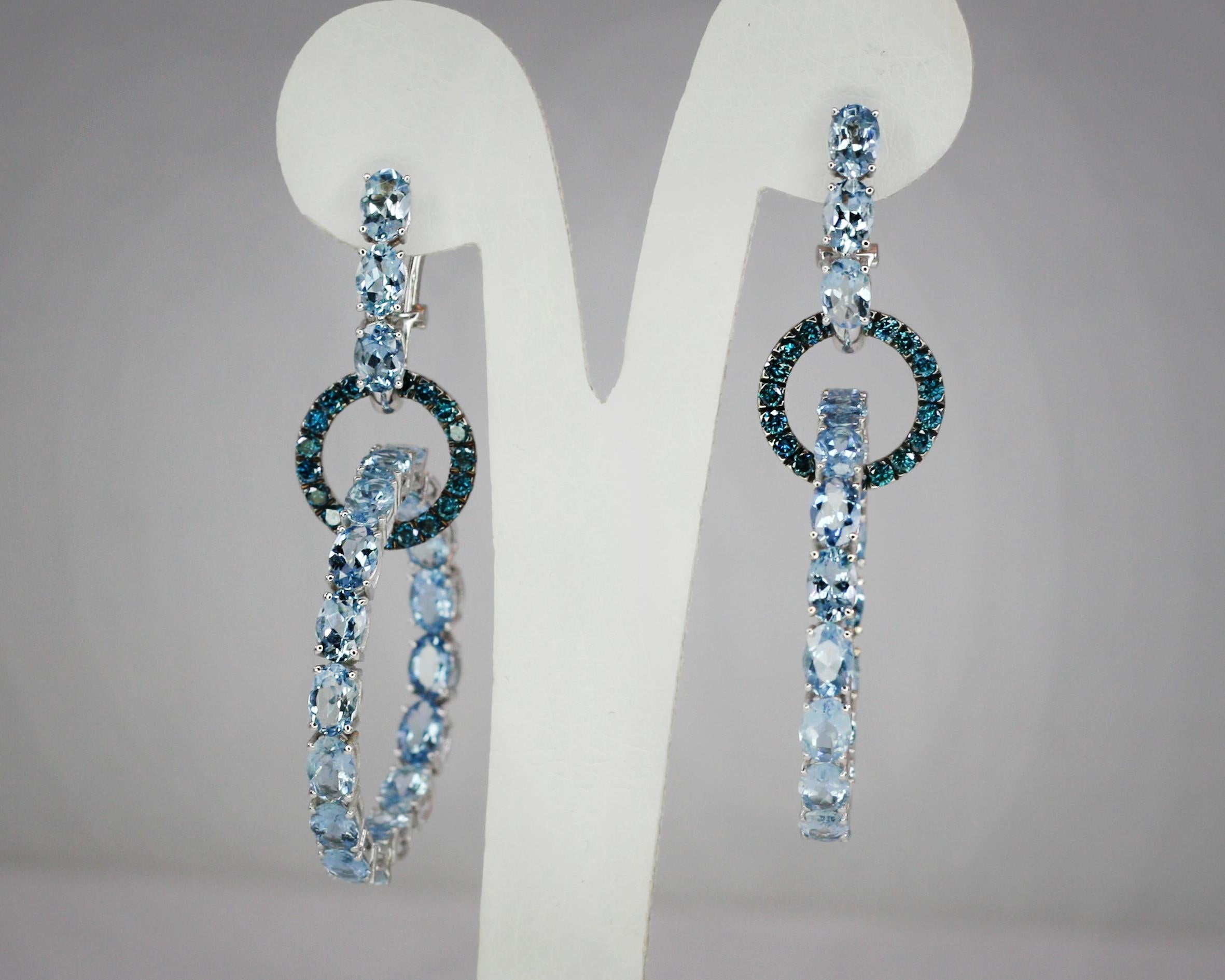 These S.Georgios designer hoop earrings in White Gold 18 Karat are all hand made with microscopic settings. These gorgeous earrings feature 2 interconnected hoops made of oval cut natural Aquamarines total weight of 16.20 Carat and brilliant-cut