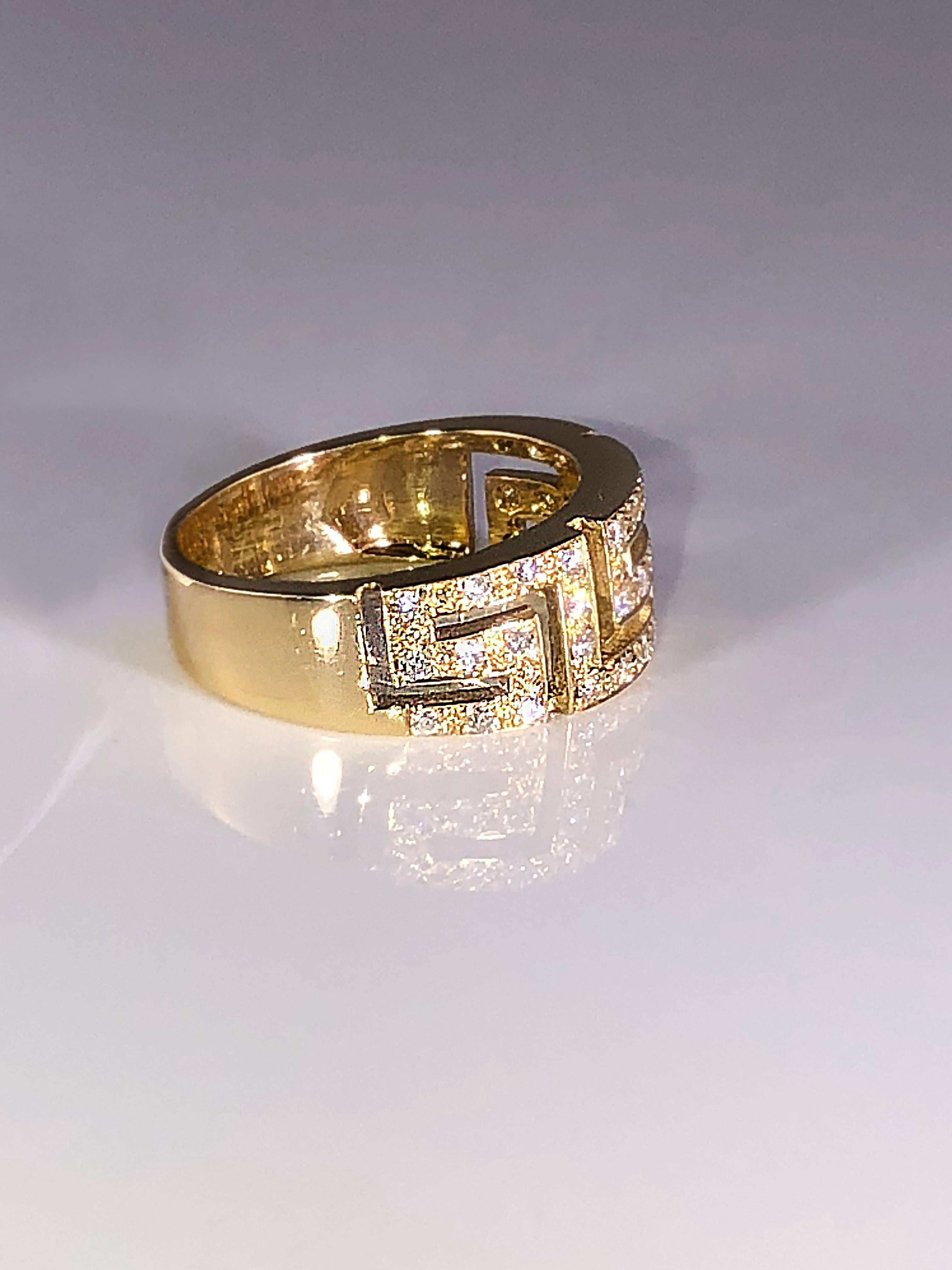La bague en or jaune 18 carats avec diamant S.Georgios est fabriquée à la main et présente le motif de la clé grecque qui symbolise l'éternité. Elle est ornée de diamants blancs taille brillant d'un poids total de 0,38 carat. Elle peut également