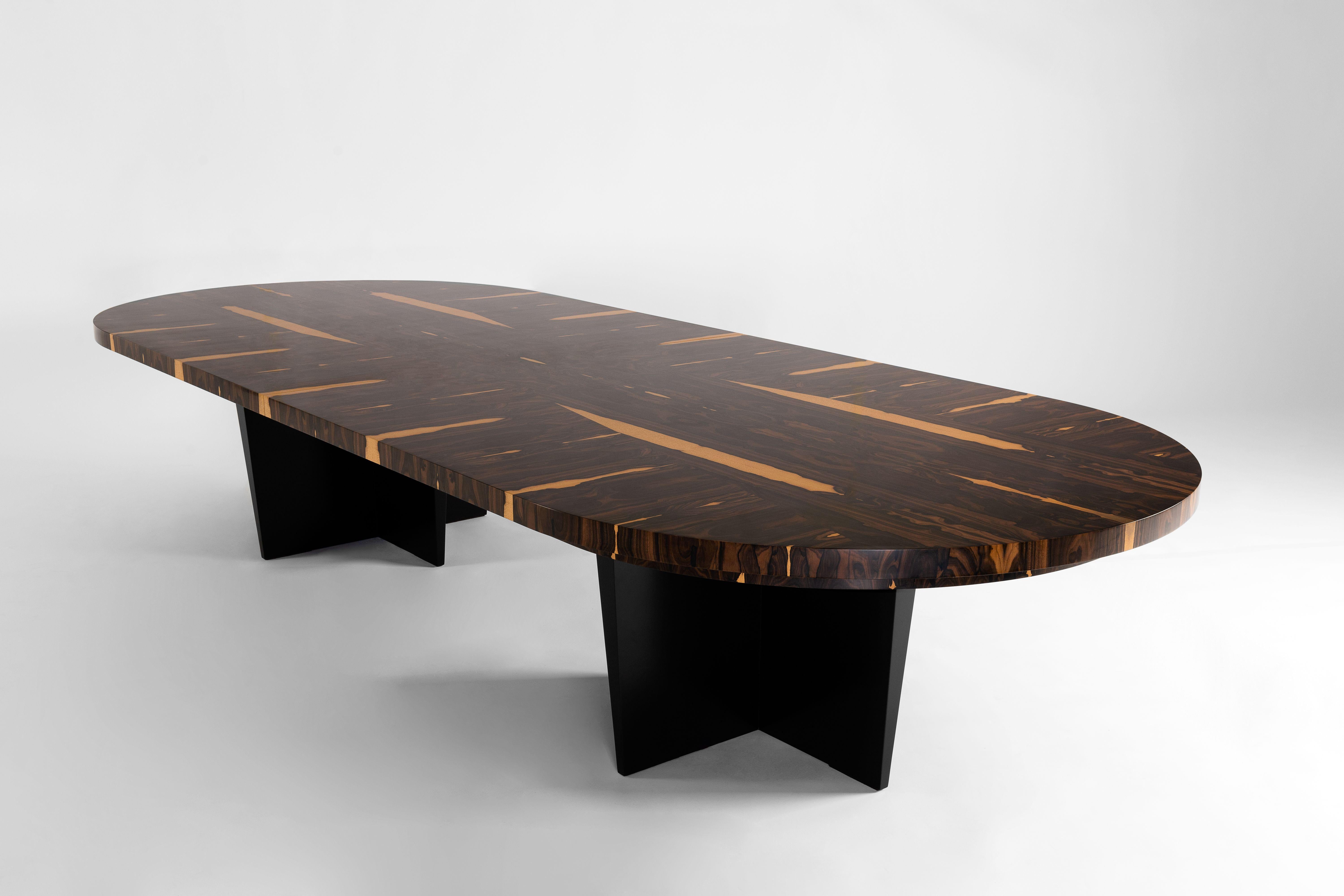 The Alaia dining table is an homage to pre-20 th century Hawaiian surfboards. The top, made from dramatically grained ziricote wood indigenous to Mexico, rests on an ebonized oak base. Ziricote is a non-threatened species often used for fine musical