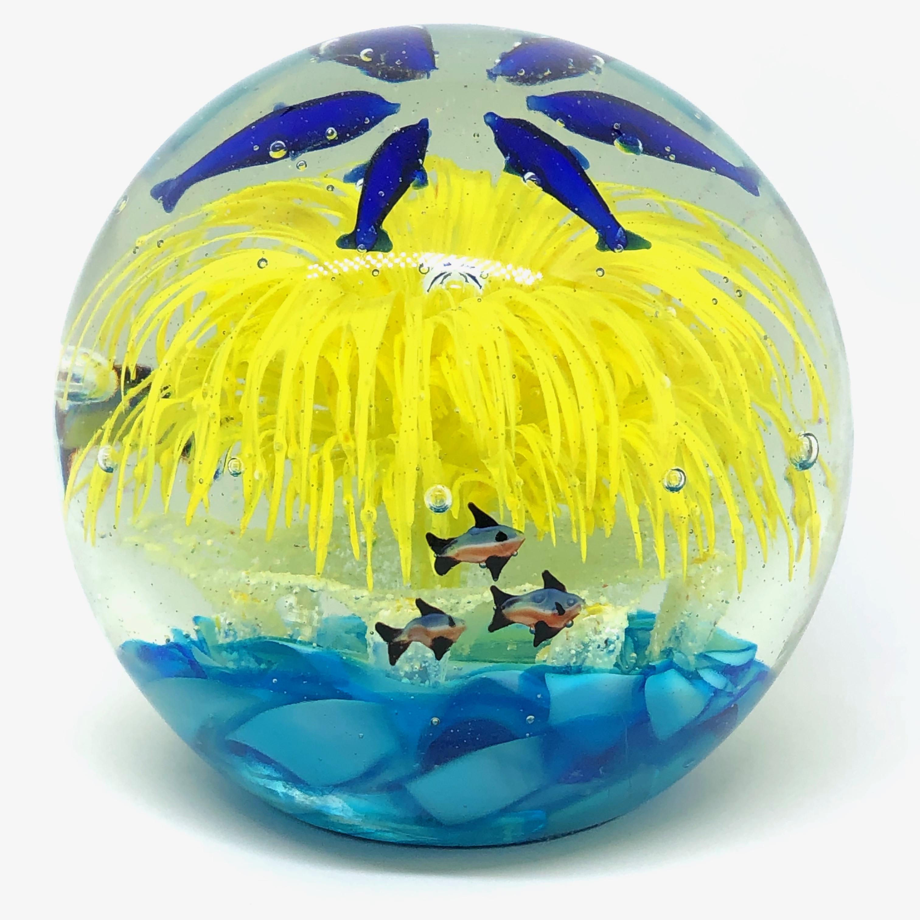 Beautiful Murano hand blown aquarium Italian art glass paper weight. Showing some blue dolphins and fishes with a Coral Reef inside, floating on controlled bubbles. Colors are a blue, yellow and clear. A beautiful nice addition to your desktop or as