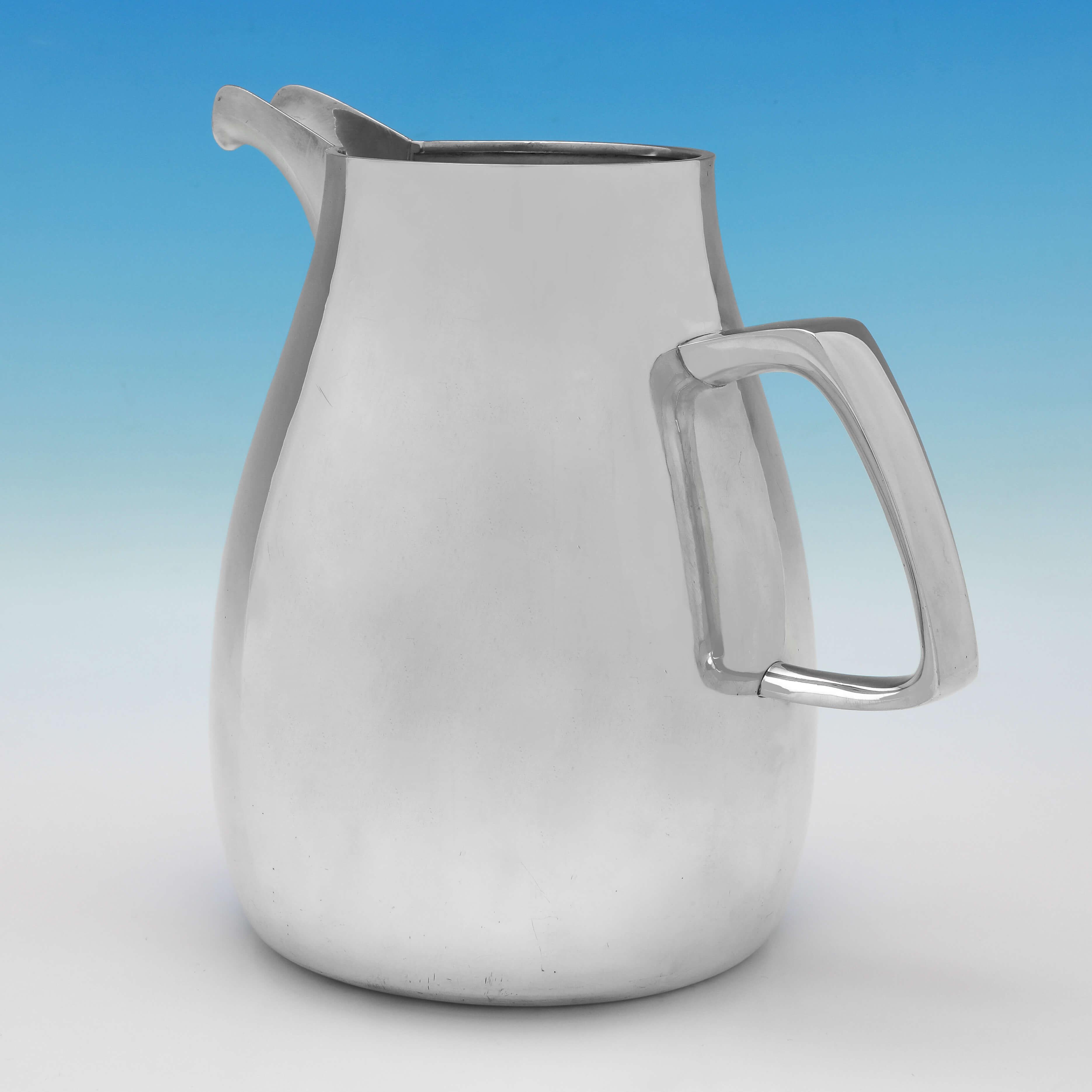 Hallmarked in London in 1965 by Gerald Benney, this handsome, Sterling Silver Beer Jug or Water Jug, is plain in style, with an angular handle. 

The jug measures 9