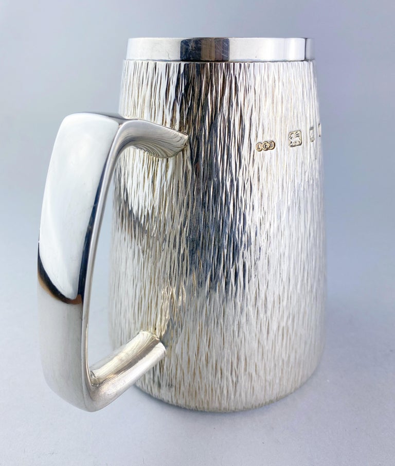 Gerald Benney - vintage sterling silver tankard
Maker: Gerald Benney
Made in London, 1971
Fully hallmarked.

Dimensions:
Length 13.8 cm
Width 10 cm
Height 13.1 cm
Weight: 481 grams

Condition: Minor wear from general usage, no damage,