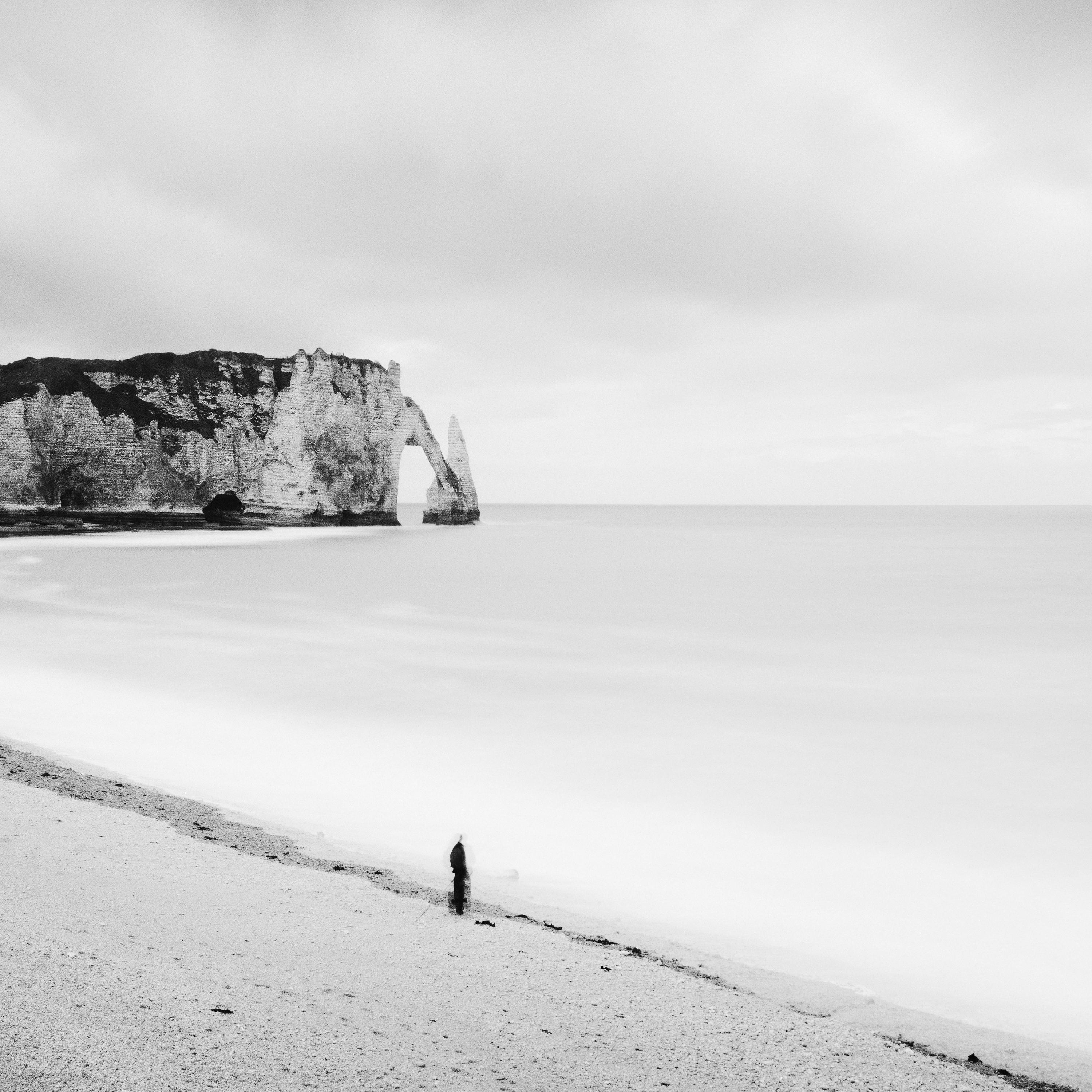 Black and white fine art landscape photography. Beautiful beach with fishermen and the impressive rock formation of Etretat, France.. Archival pigment ink print as part of a limited edition of 9. All Gerald Berghammer prints are made to order in