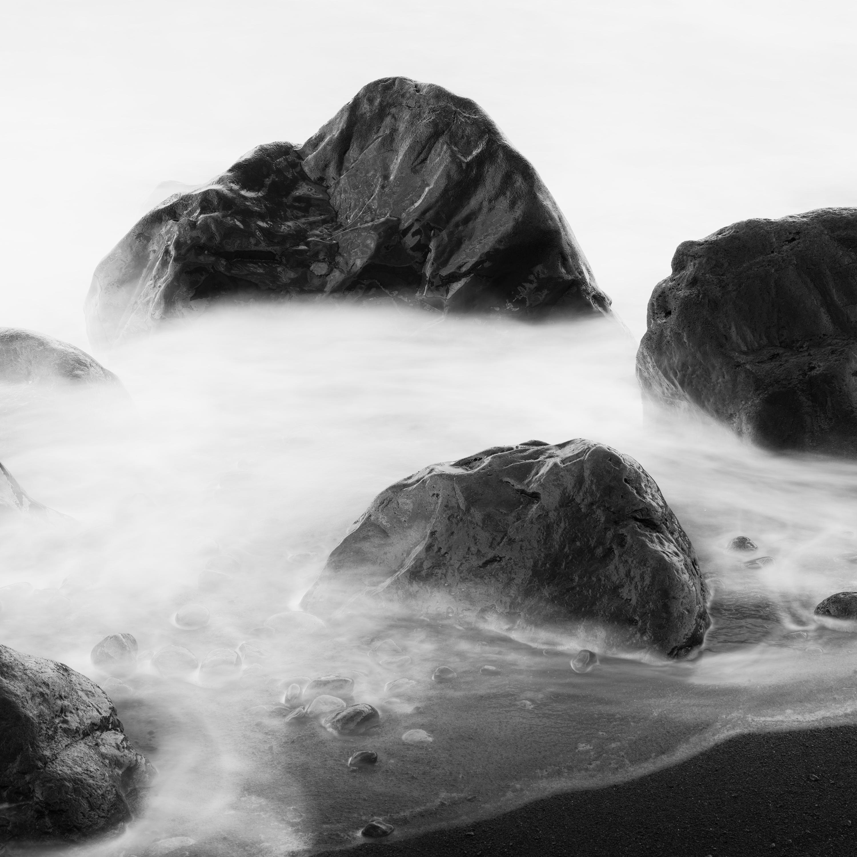 Black and white fine art long exposure waterscape - landscape photography. Big black stones in the surf at La Gomera beach, Spain. Archival pigment ink print as part of a limited edition of 7. All Gerald Berghammer prints are made to order in