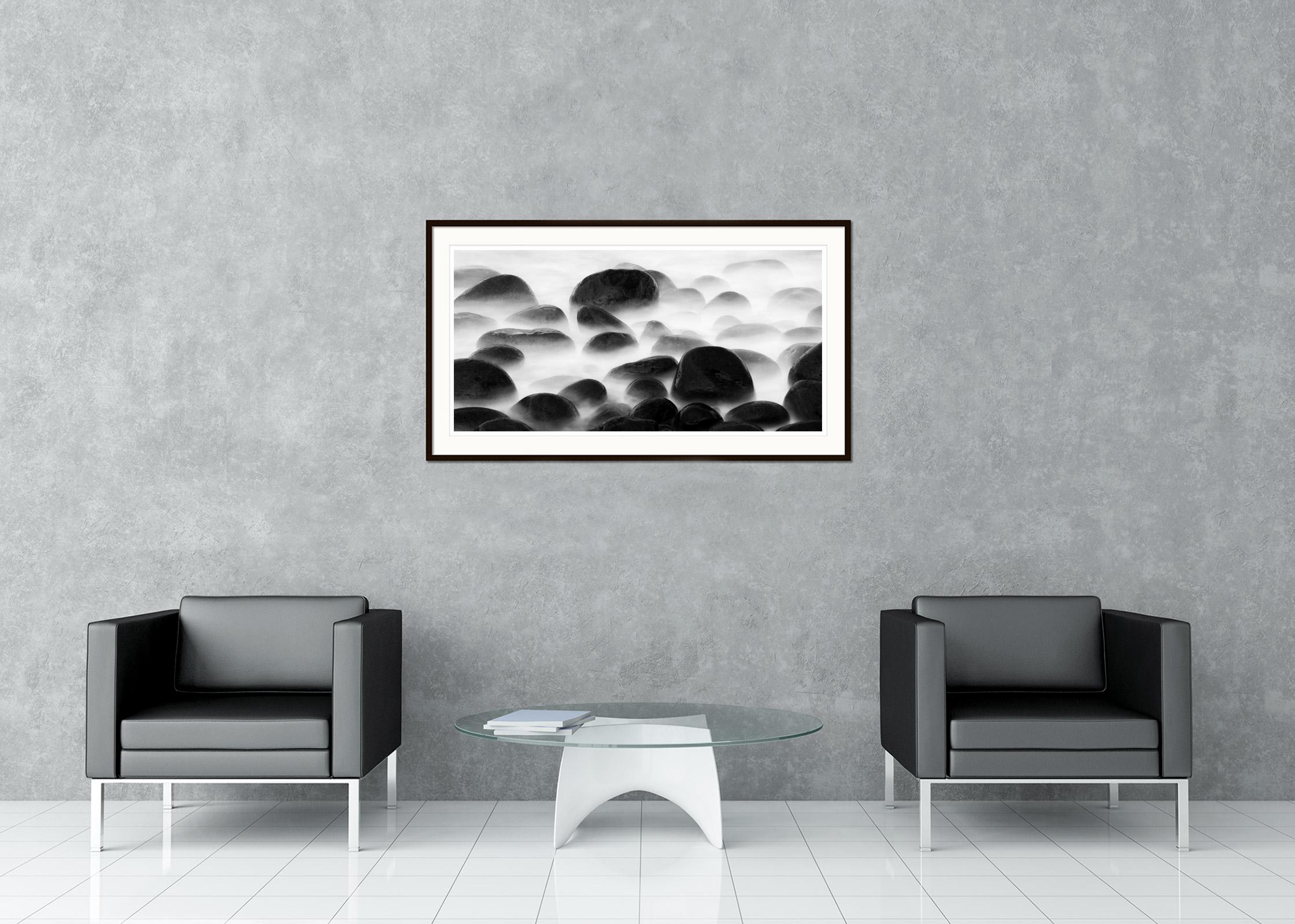 Black and white fine art long exposure waterscape - landscape photography. Big black stones on the shore in madeira, Portugal. Archival pigment ink print as part of a limited edition of 5. All Gerald Berghammer prints are made to order in limited