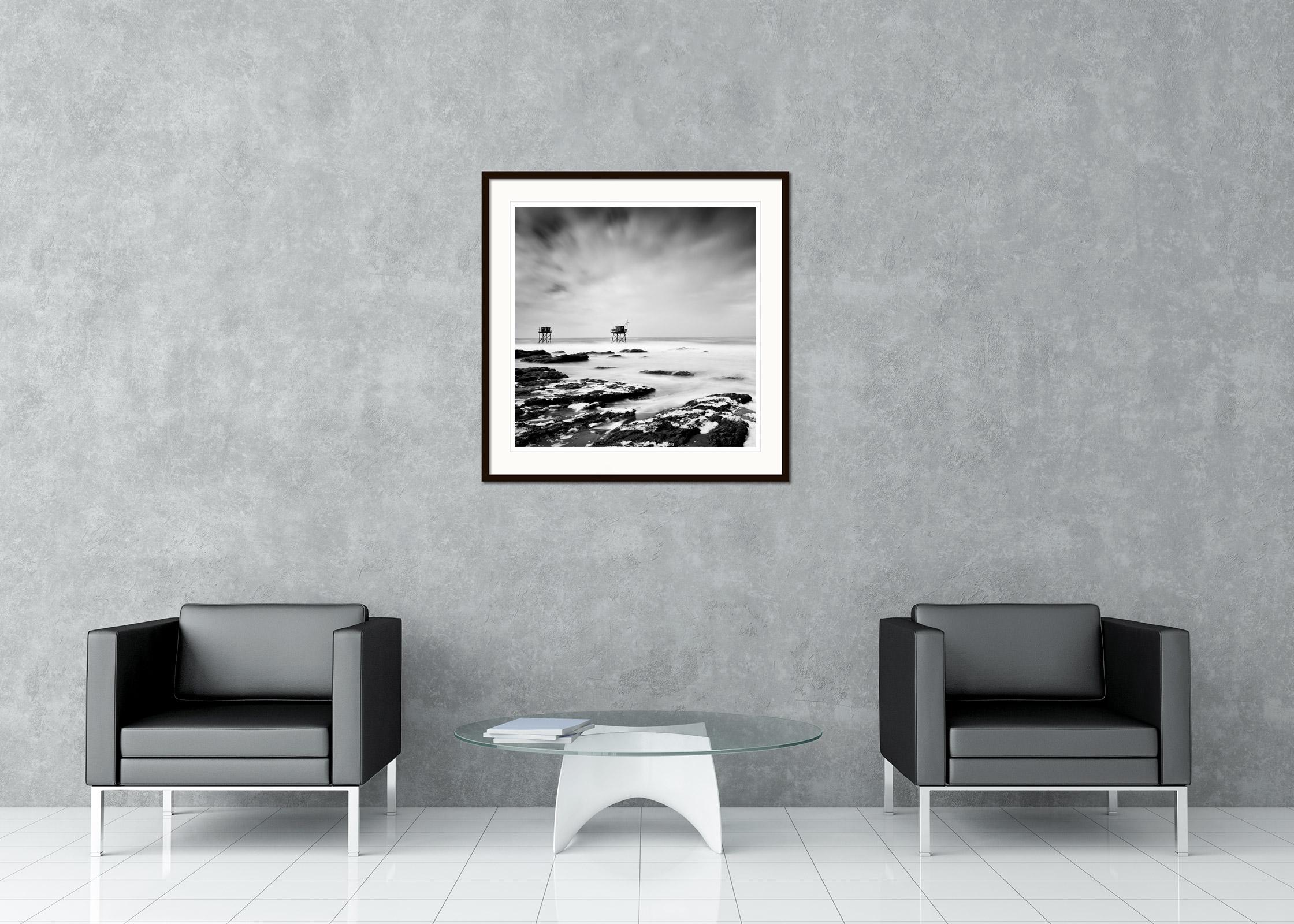 Stampa fotografica in bianco e nero a lunga esposizione di un paesaggio acquatico. Capanne di pescatori su palafitte nel mare selvaggio della costa atlantica francese. Stampa a inchiostro pigmentato d'archivio, edizione di 7 esemplari. Firmato,