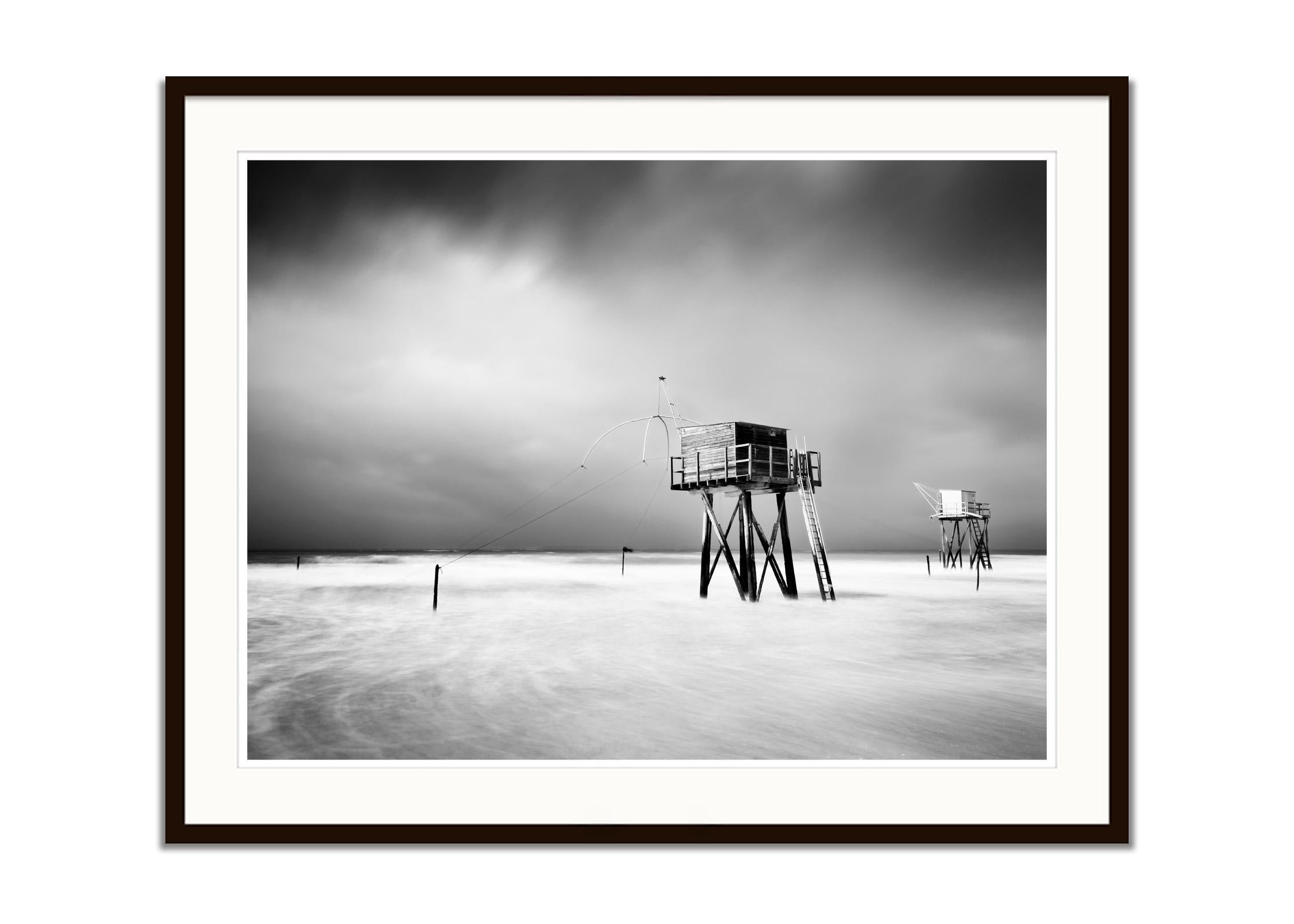 Fishing Hut On Stilts, surf, shoreline, storm, black white landscape photography - Gray Black and White Photograph by Gerald Berghammer