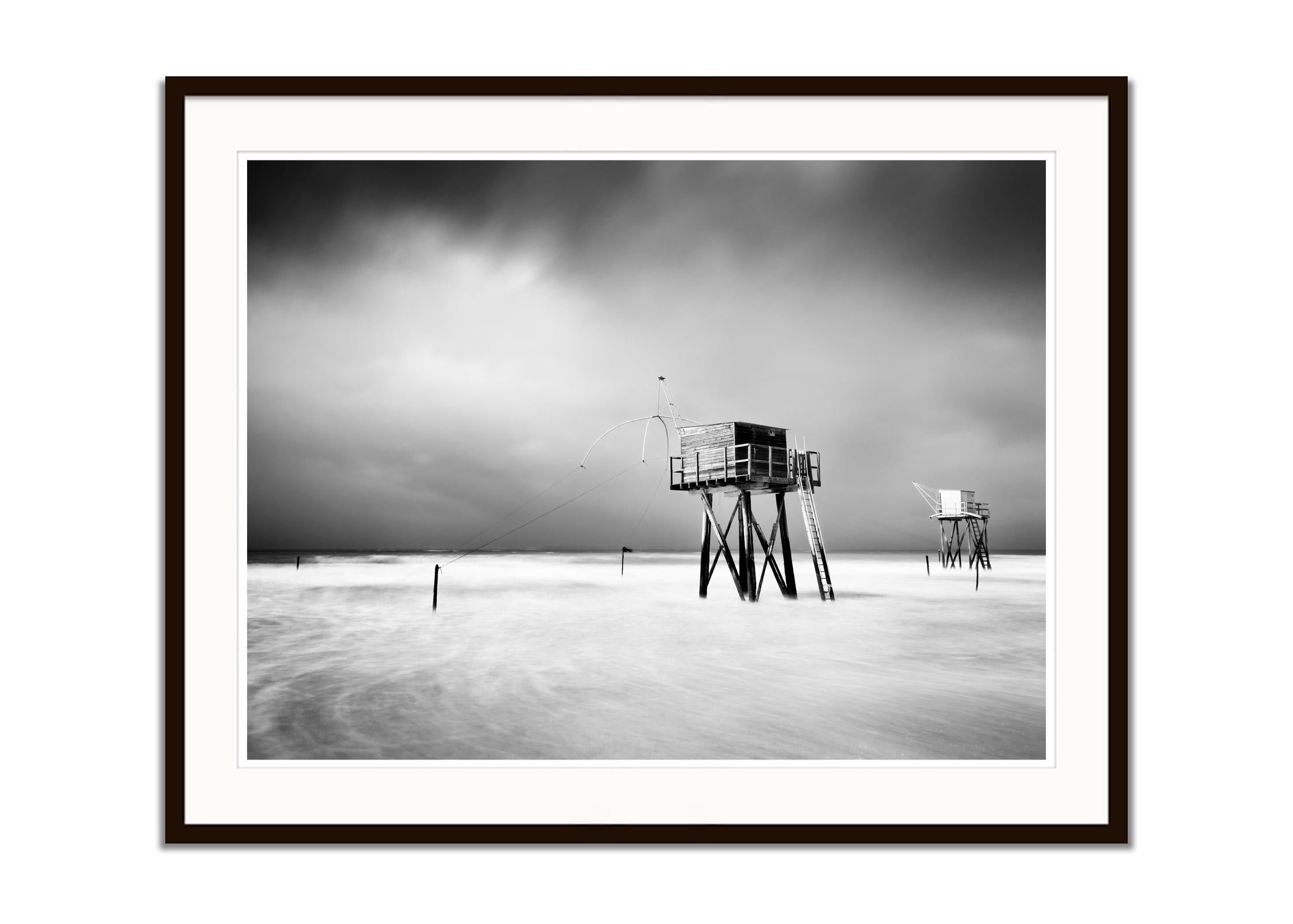 Fishing Hut on Stilts, shoreline, storm, black white photography, landscape, art - Gray Color Photograph by Gerald Berghammer