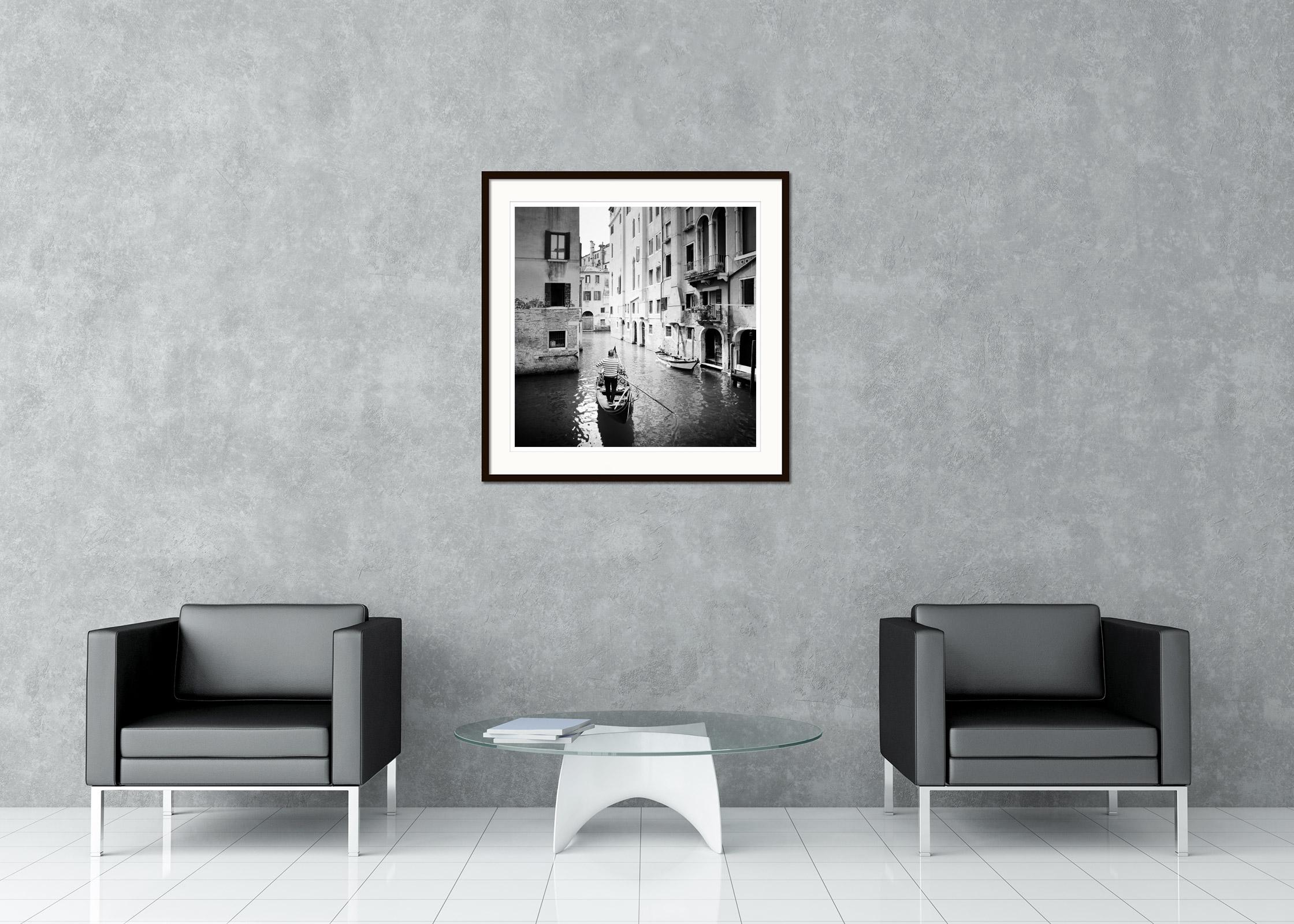 Fotografía artística en blanco y negro de paisajes urbanos. Gondolero en pequeño canal de agua con hermosas casas en Venecia, Italia. Impresión en tinta de pigmento de archivo, edición de 9. Firmada, titulada, fechada y numerada por el artista.
