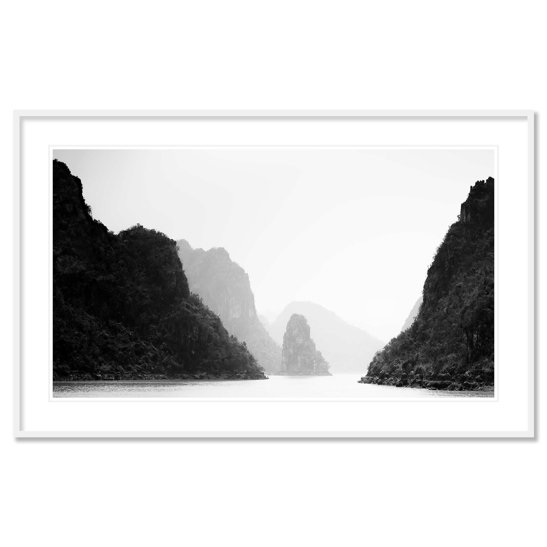 The sea narrows through limestone cliffs in hazy light with mountains in the background.
Archival pigment ink print as part of a limited edition of 7. 

All Gerald Berghammer prints are made to order in limited editions on Hahnemuehle Photo Rag