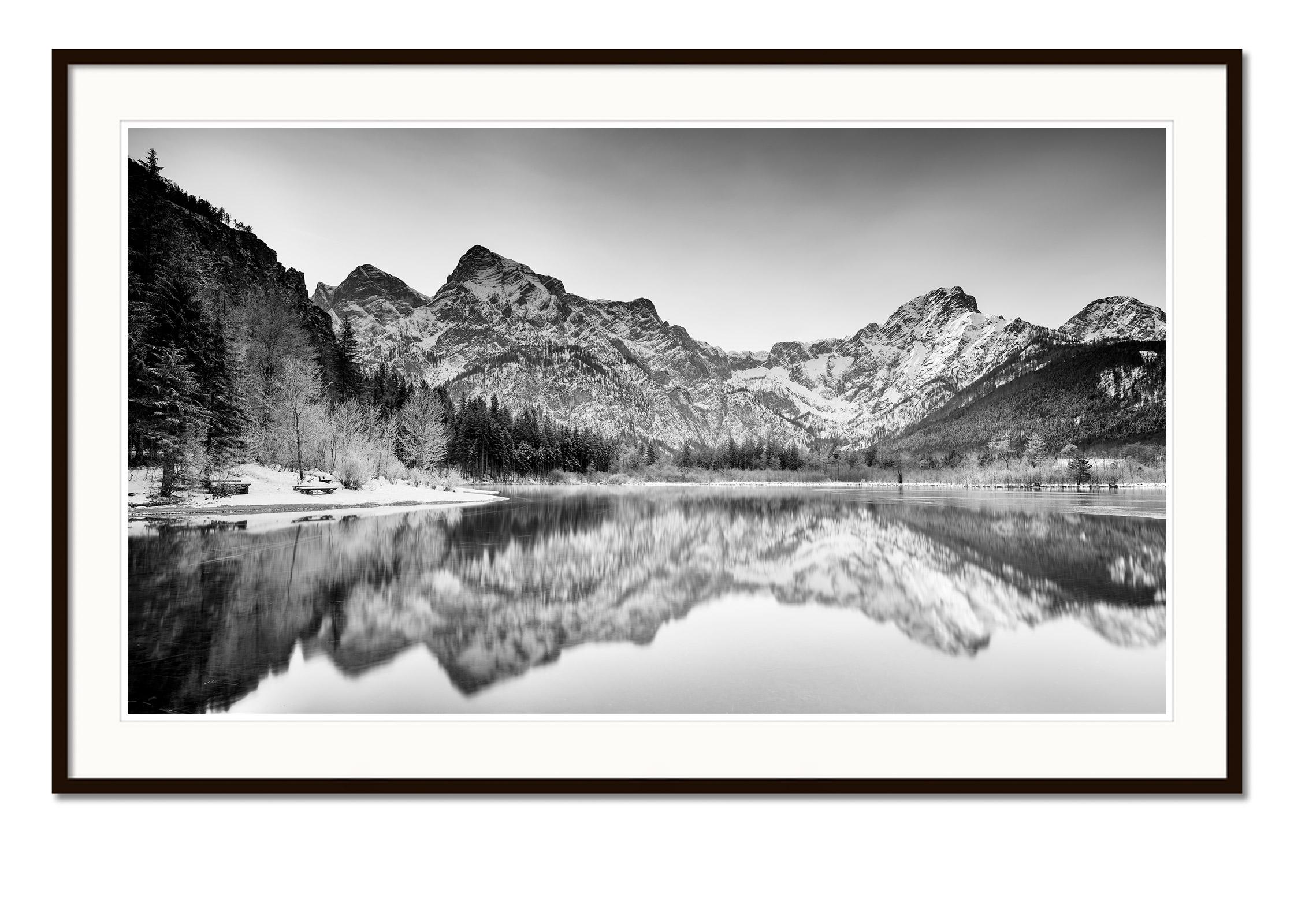 Black and white fine art panorama long exposure landscape photography. Lake side winter panorama with mountains, lake and beautiful reflections in the water, Almsee, Austria. Archival pigment ink print, edition of 8. Signed, titled, dated and