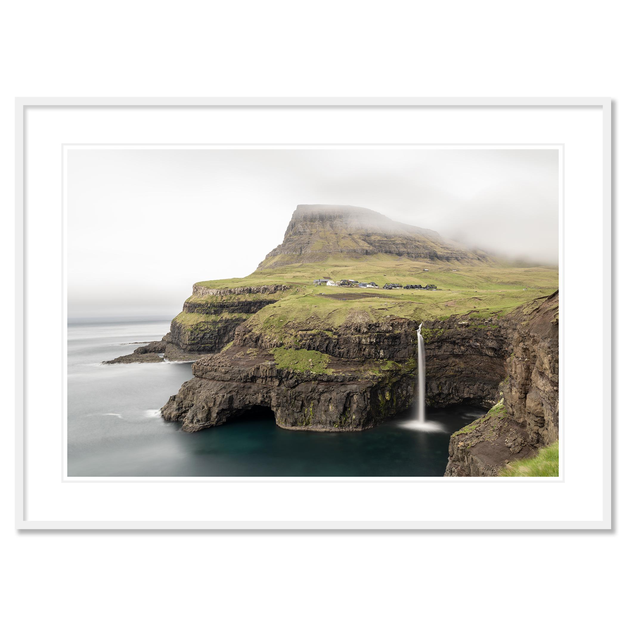 Gerald Berghammer - Fotografía en color. Paisaje costero que presenta una meseta elevada con una cascada que cae al océano, parcialmente oscurecida por la niebla.
Impresión en tinta pigmentada, edición limitada de 7. Las impresiones se realizan por