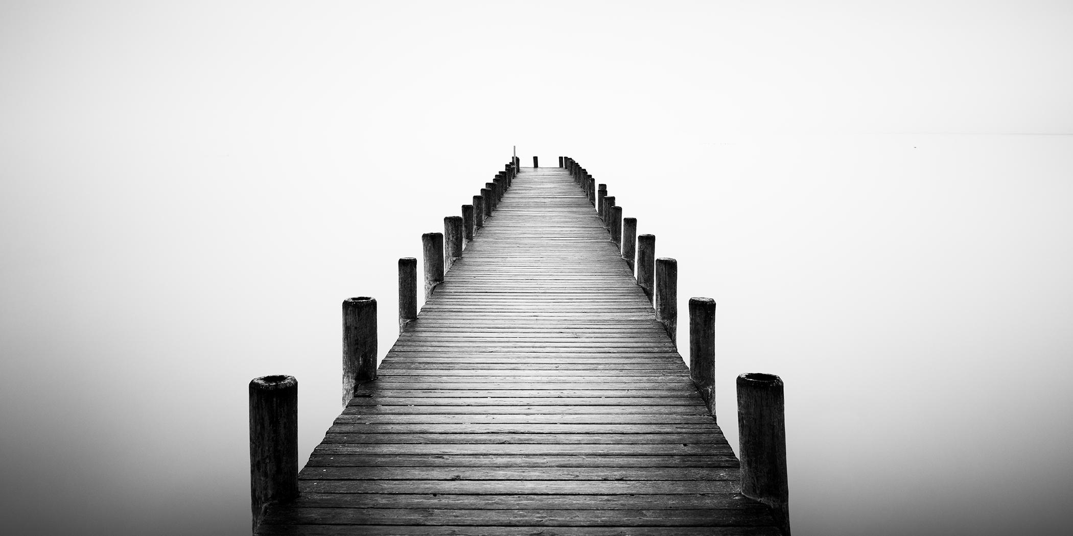 Panorama d
une jetée sur un lac brumeux, photographie noir et blanc en pose longue, limitée