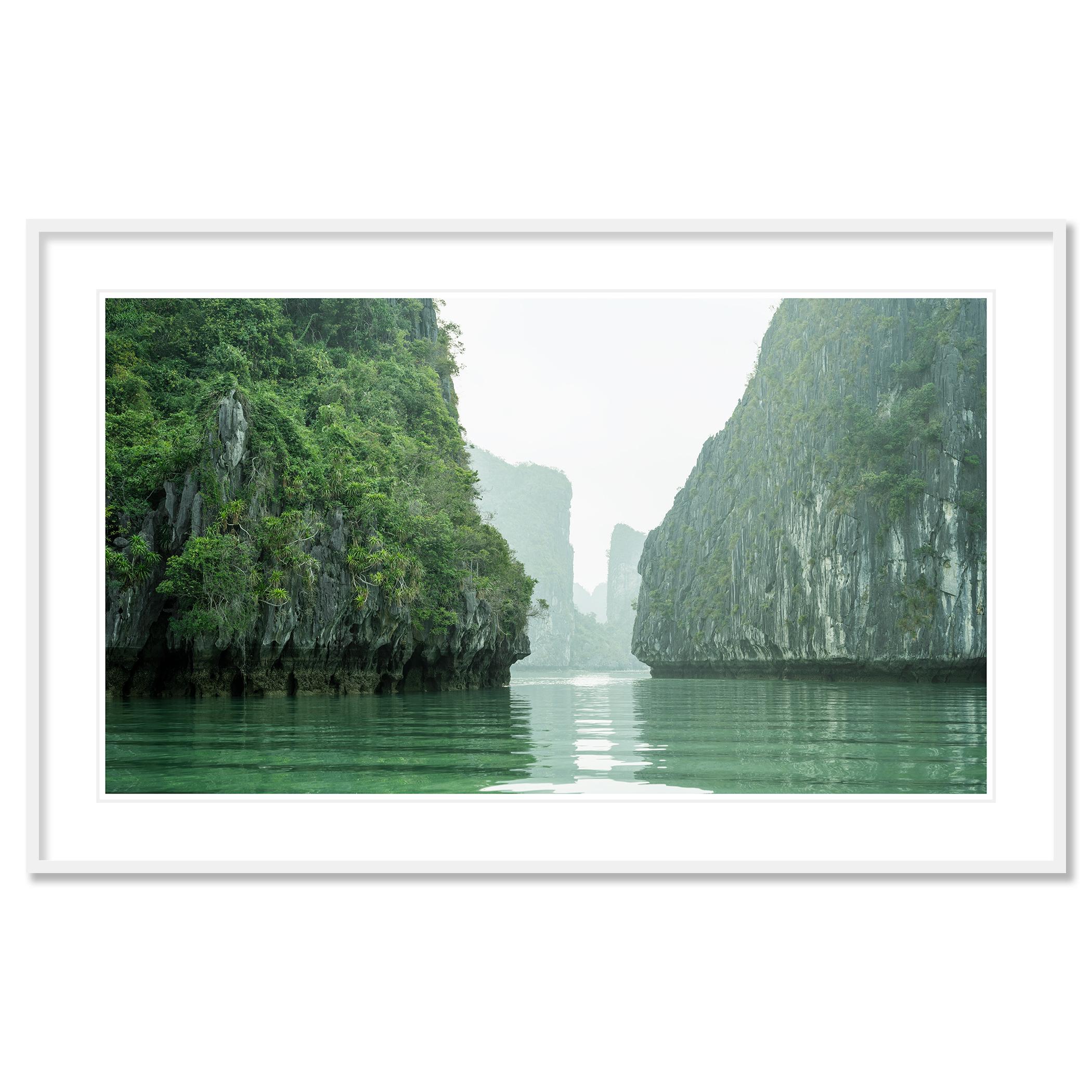 Gerald Berghammer - Photographie de paysages en couleur. Des falaises verdoyantes entourant un cours d'eau calme et émeraude à l'atmosphère brumeuse.
Tirage à l'encre pigmentaire d'archives faisant partie d'une édition limitée à 7 exemplaires.