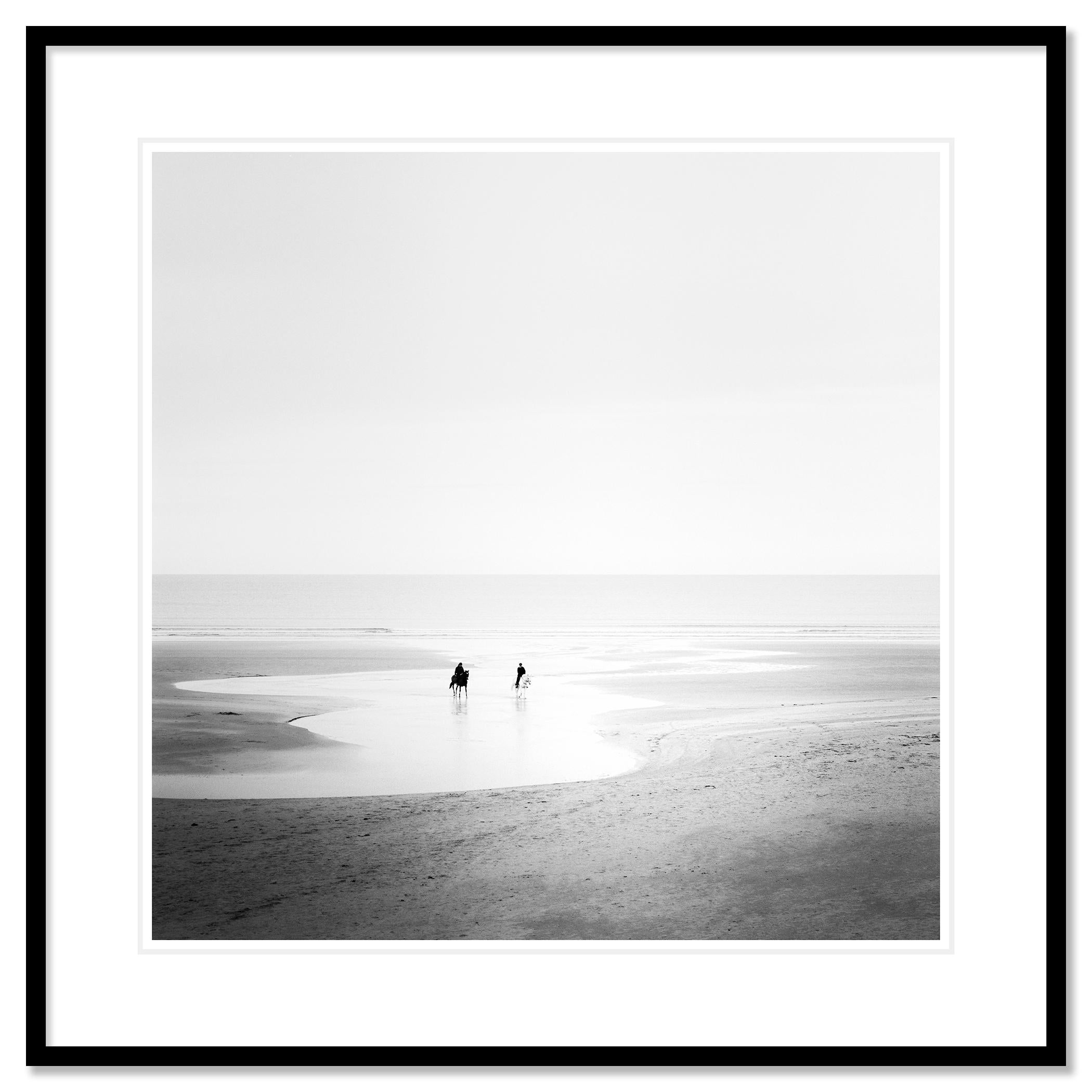 Black and white fine art landscape photography. Horse riders on deserted sandy beach in north Ireland. Archival pigment ink print as part of a limited edition of 9. All Gerald Berghammer prints are made to order in limited editions on Hahnemuehle