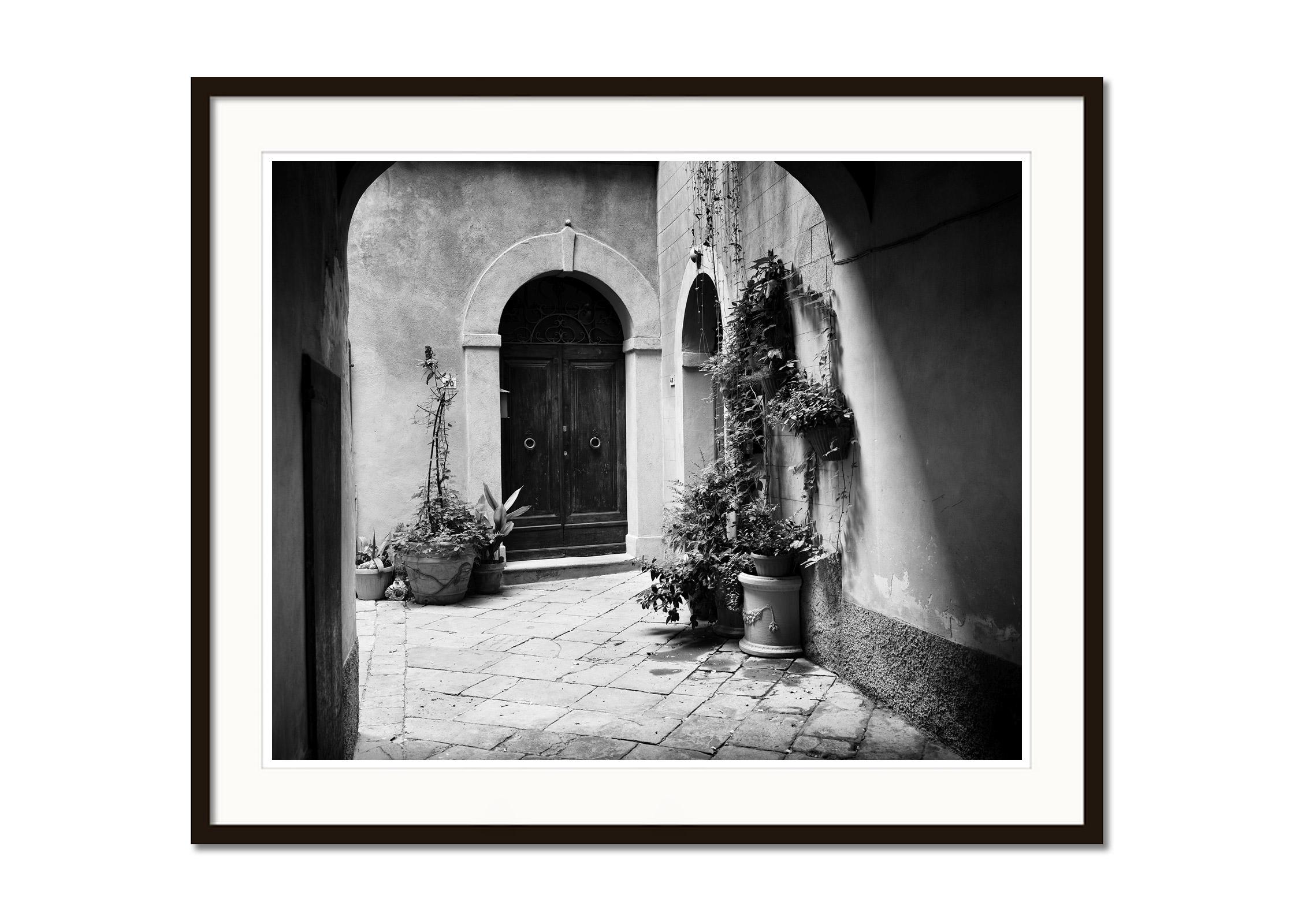 Black and white fine art cityscape - landscape photography. Beautiful courtyard with plants and an old front door, Tuscany, Itlay. Archival pigment ink print, edition of 8. Signed, titled, dated and numbered by artist. Certificate of authenticity