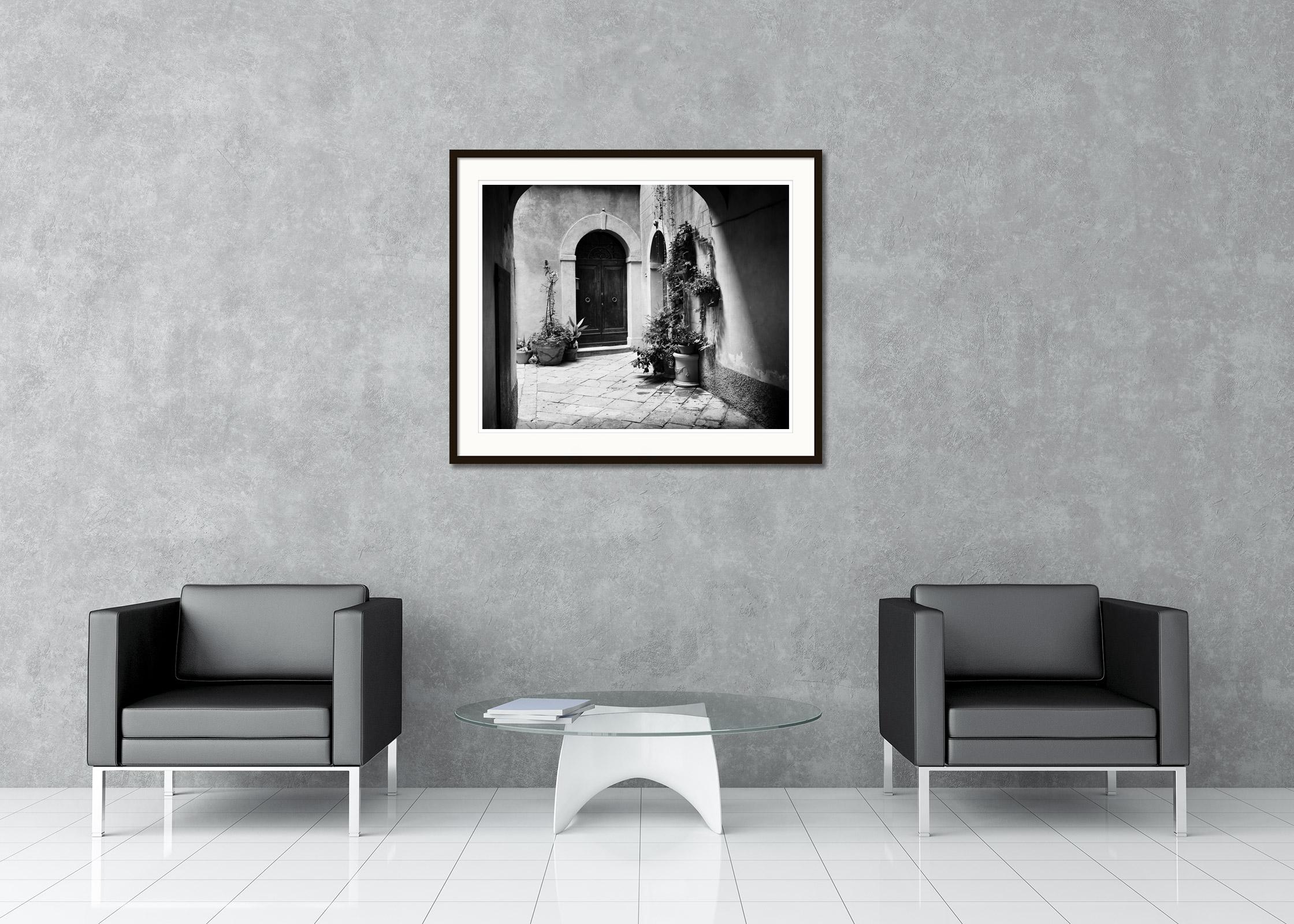 Black and white fine art cityscape - landscape photography. Beautiful courtyard with plants and an old front door, Tuscany, Itlay. Archival pigment ink print, edition of 5. Signed, titled, dated and numbered by artist. Certificate of authenticity