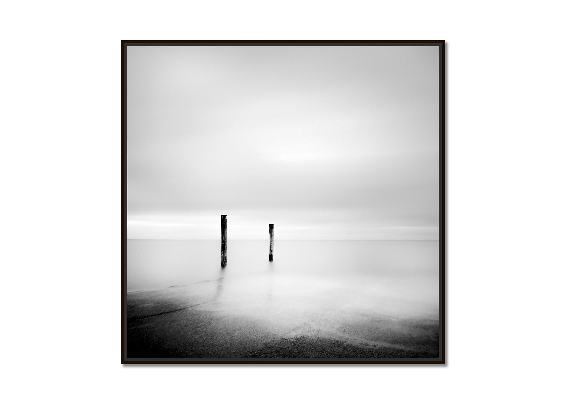 Two Wooden Stakes, Sylt, Germany, black and white long exposure art photography - Photograph by Gerald Berghammer