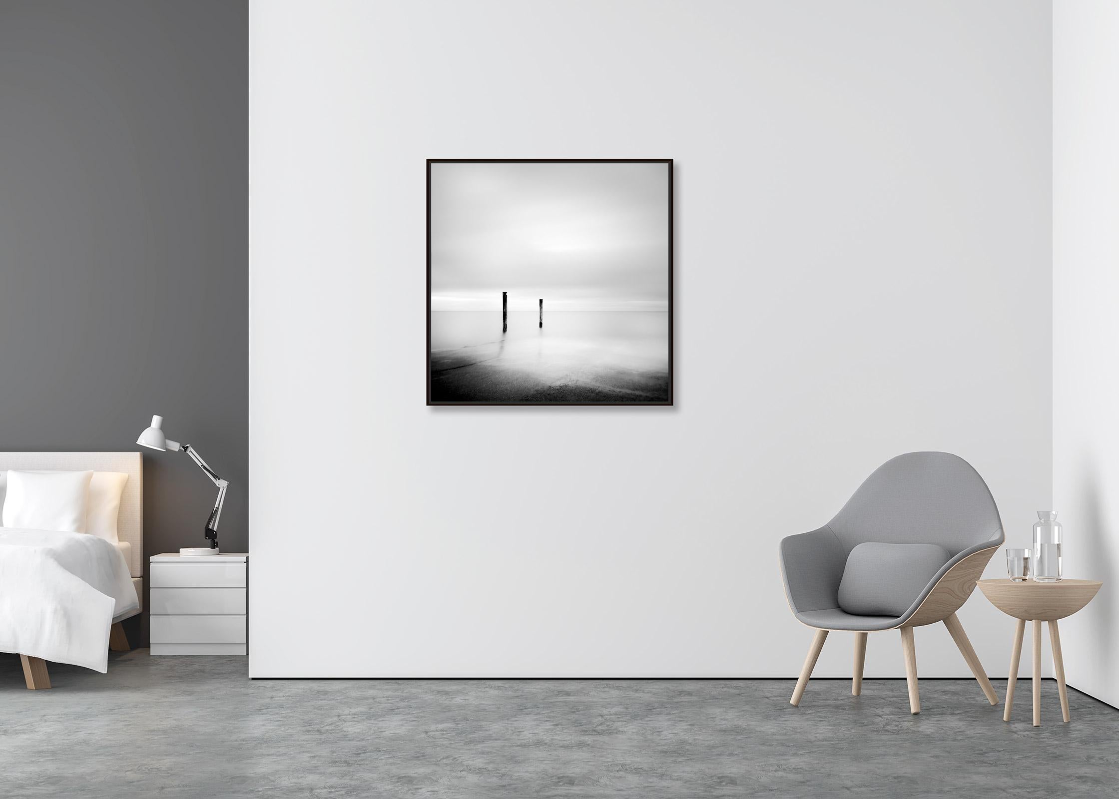 Two Wooden Stakes, Sylt, Germany, black and white long exposure art photography - Contemporary Photograph by Gerald Berghammer
