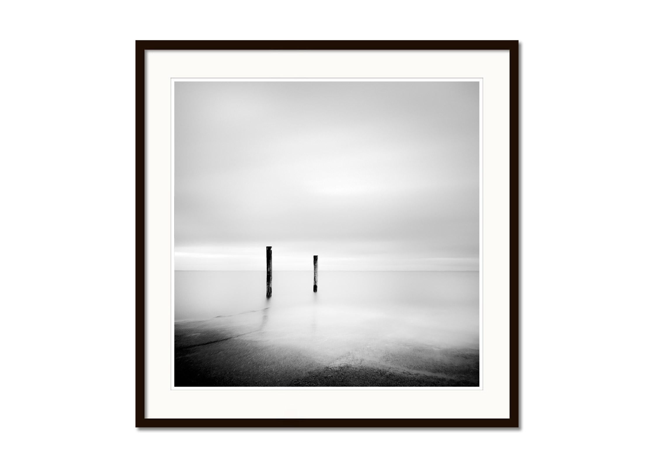 Two Wooden Stakes, Sylt, Germany, black and white long exposure art photography - Gray Black and White Photograph by Gerald Berghammer