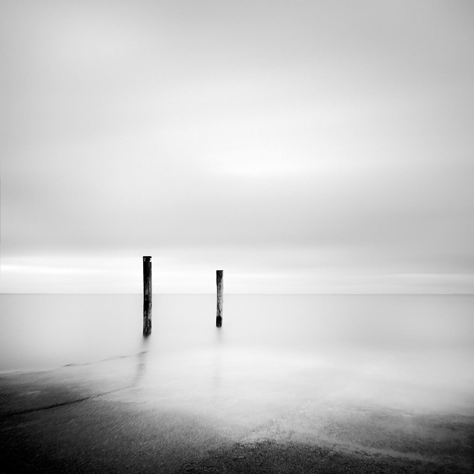 Gerald Berghammer Black and White Photograph – Zwei hölzerne Stakes, Sylt, Deutschland, Schwarz-Weiß-Fotografie mit langer Belichtung