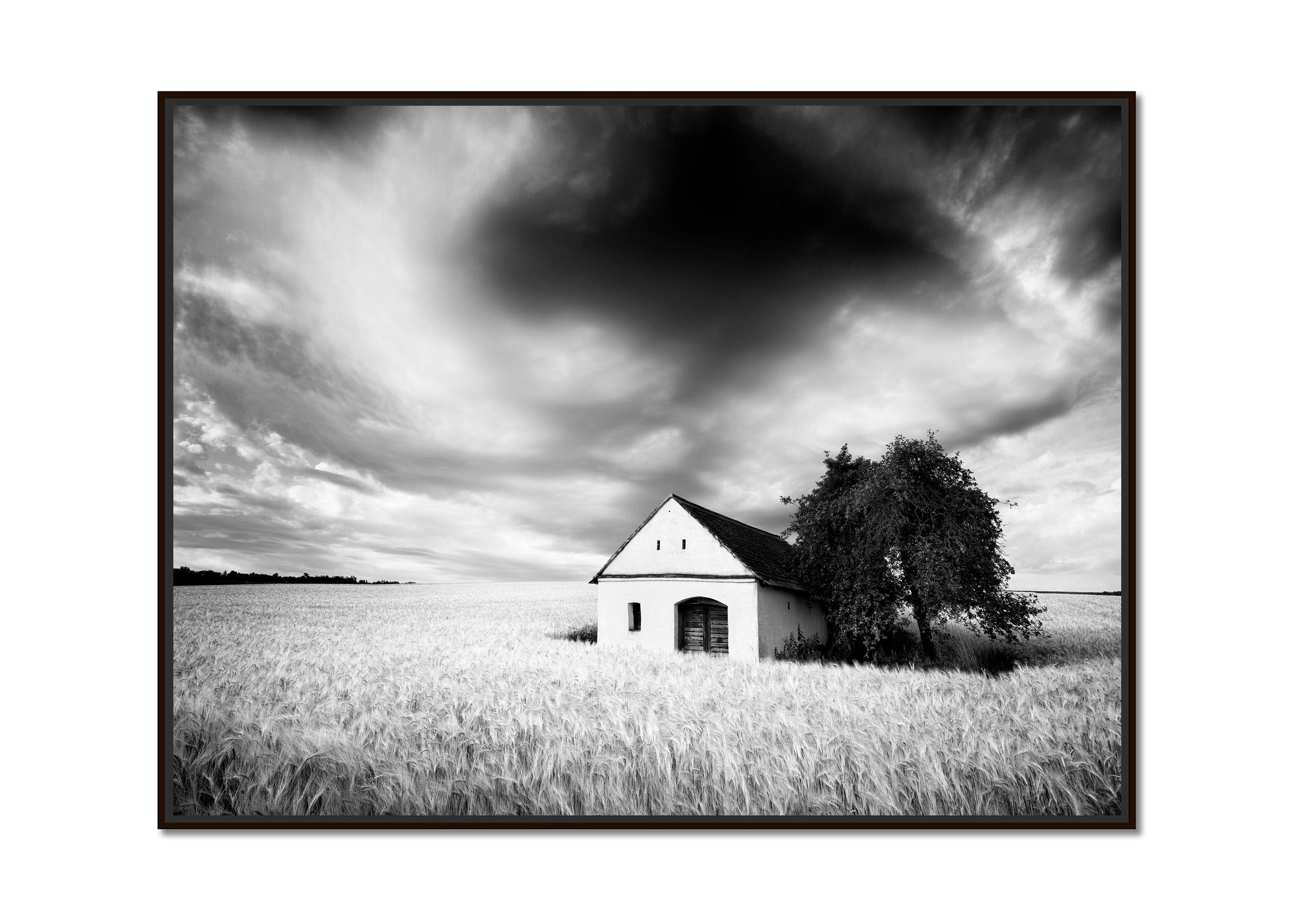 Wine Press House, wheat field, heavy clouds, black & white landscape photography - Photograph by Gerald Berghammer