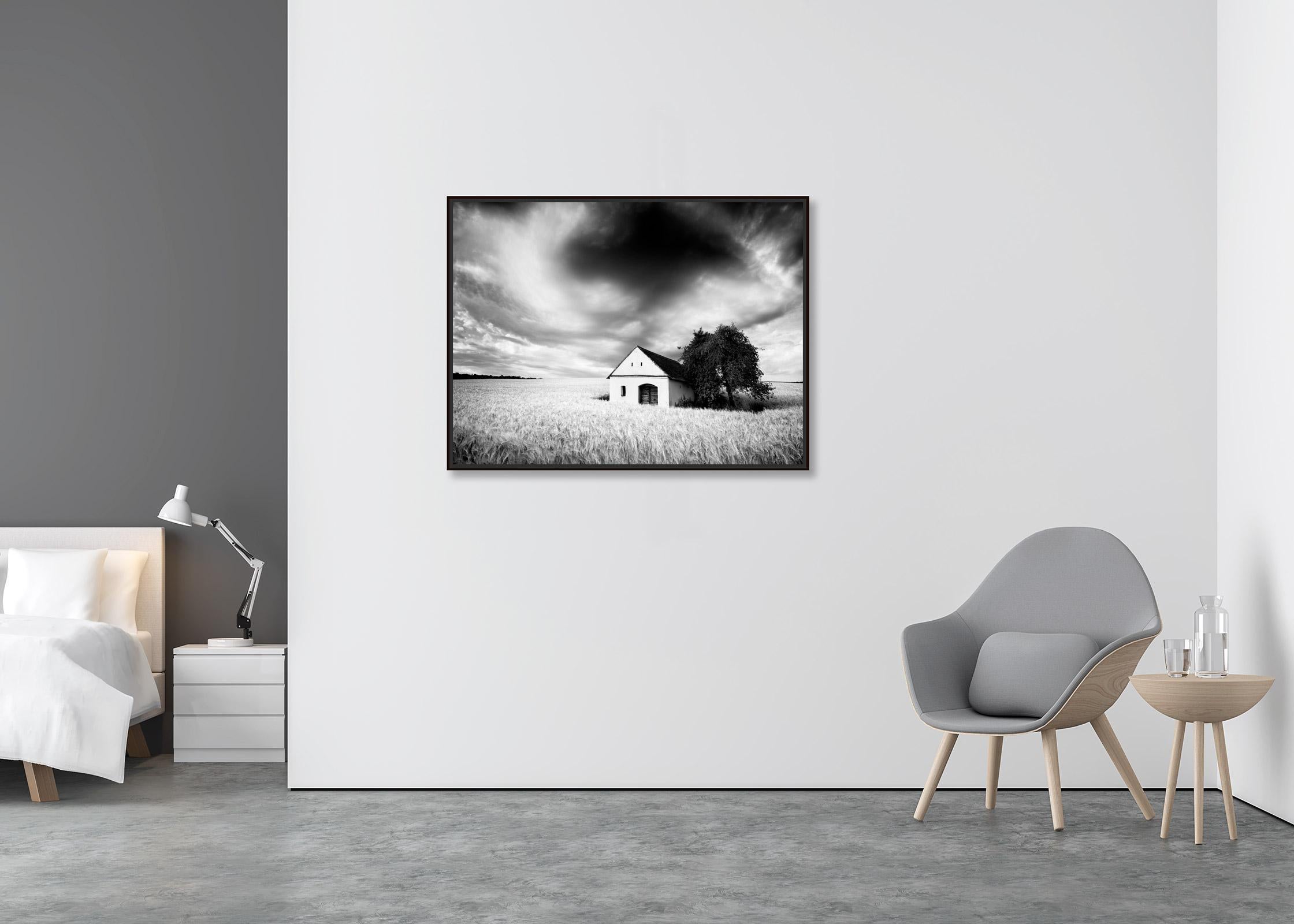Wine Press House, wheat field, heavy clouds, black & white landscape photography - Contemporary Photograph by Gerald Berghammer