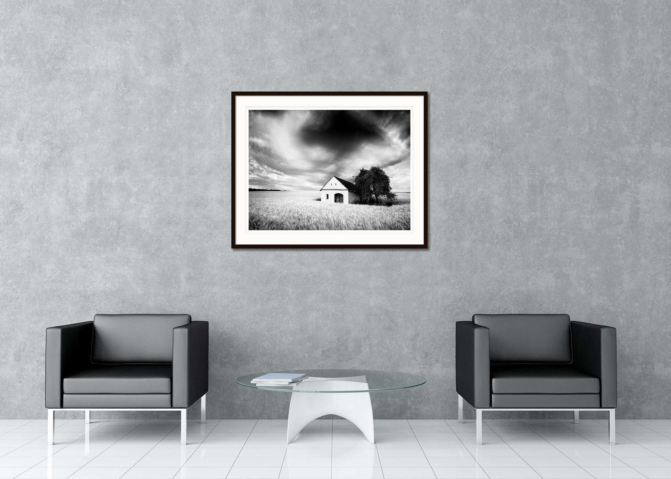 Fotografía artística de paisajes en blanco y negro. Lagar en un campo de trigo, nubes densas, tormenta, Austria. Impresión en tinta de pigmento de archivo, edición de 8. Firmada, titulada, fechada y numerada por el artista. Certificado de