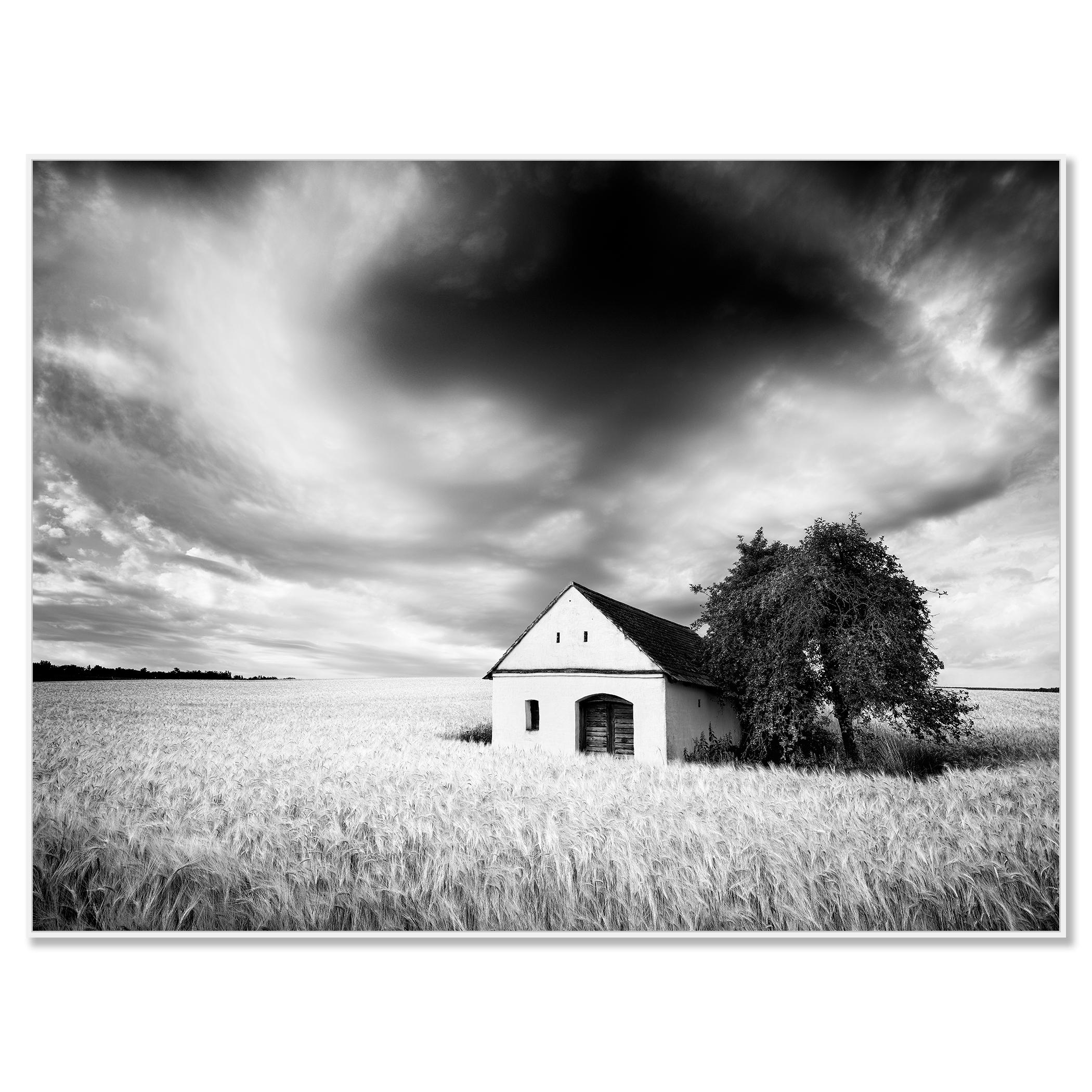 Maison du pressoir, champ de blé, nuages lourds, photographie de paysage en noir et blanc - Photograph de Gerald Berghammer