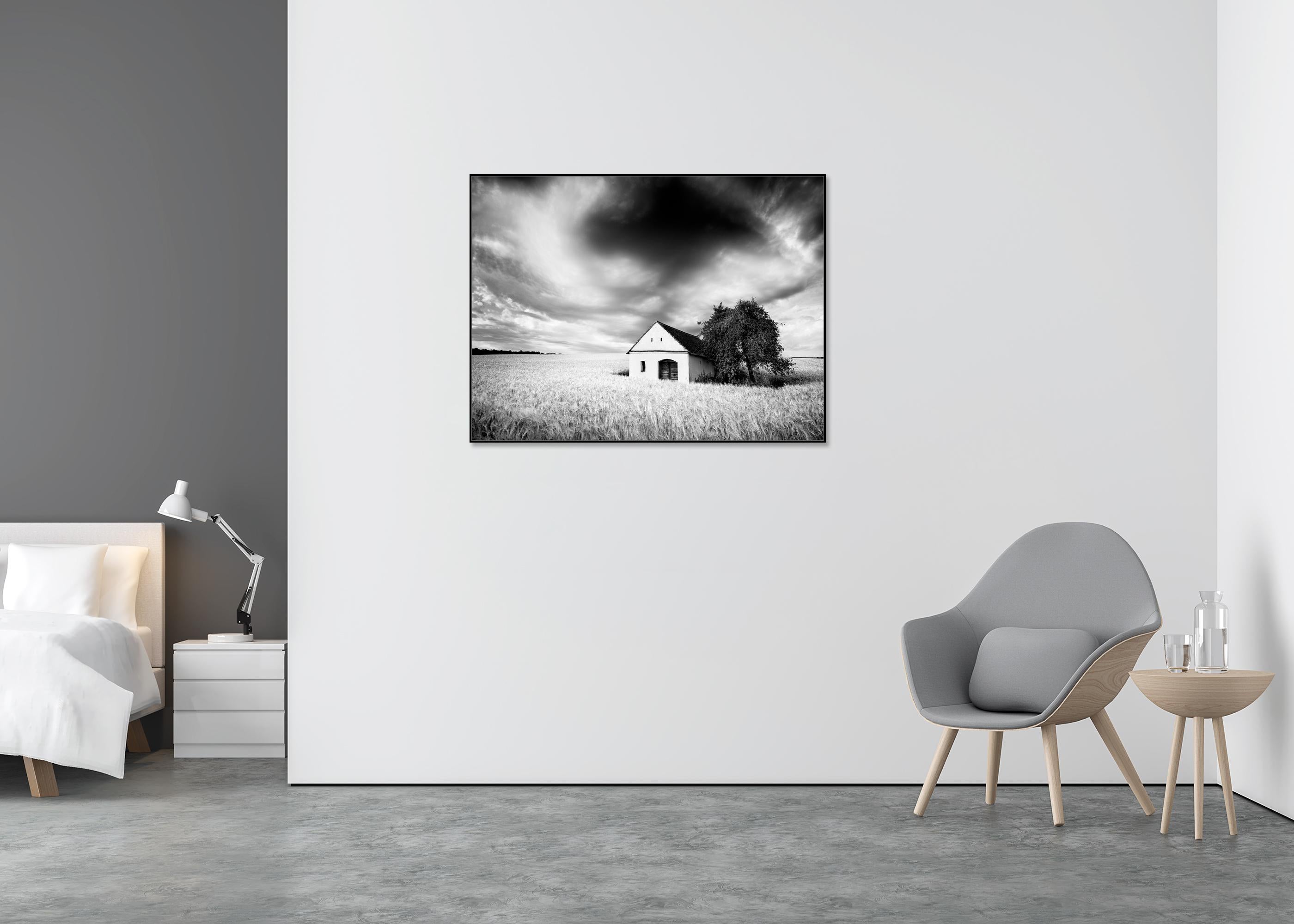Maison du pressoir, champ de blé, nuages lourds, photographie de paysage en noir et blanc - Gris Black and White Photograph par Gerald Berghammer